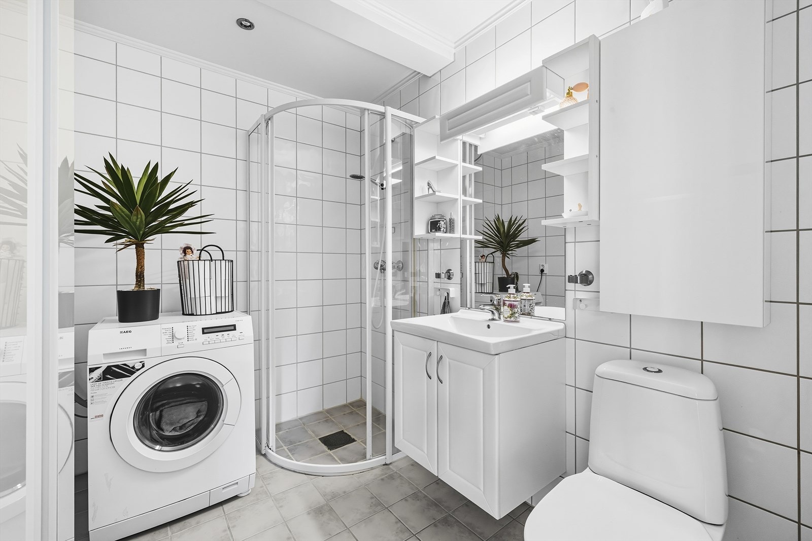 Det er pent bad med fliser på gulv og vegger, malt himling med downlights og varmekabler i gulvet. Galleribilde