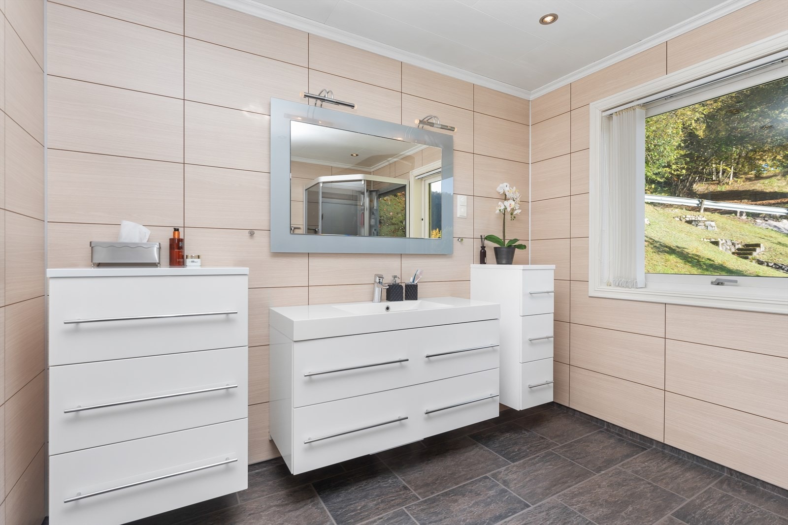 Badet har innredning med hvite skuffeseksjoner. Galleribilde