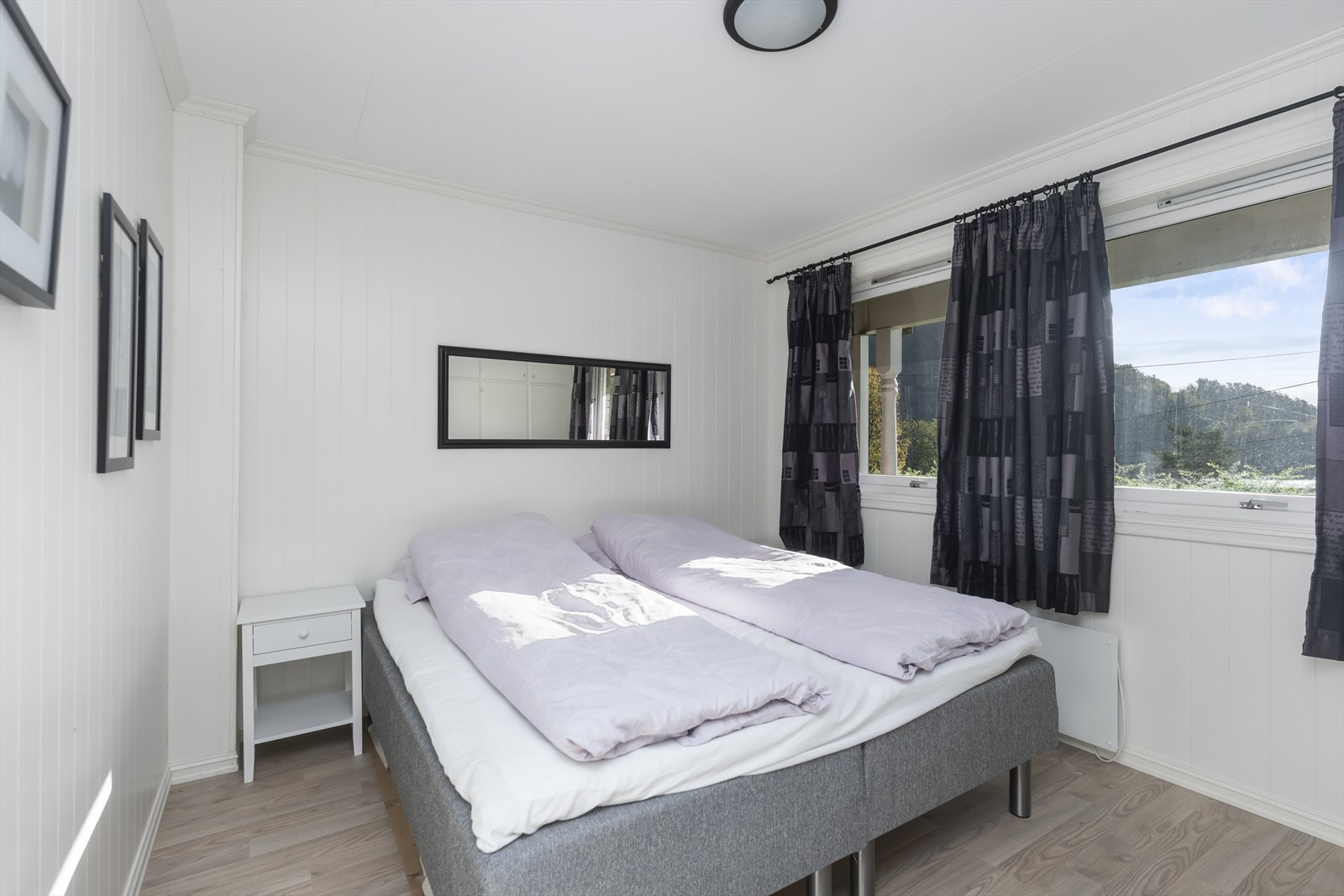 Soverommet har lyse vegger og laminatgulv, med vinduer som gir naturlig lysinnfall. Galleribilde