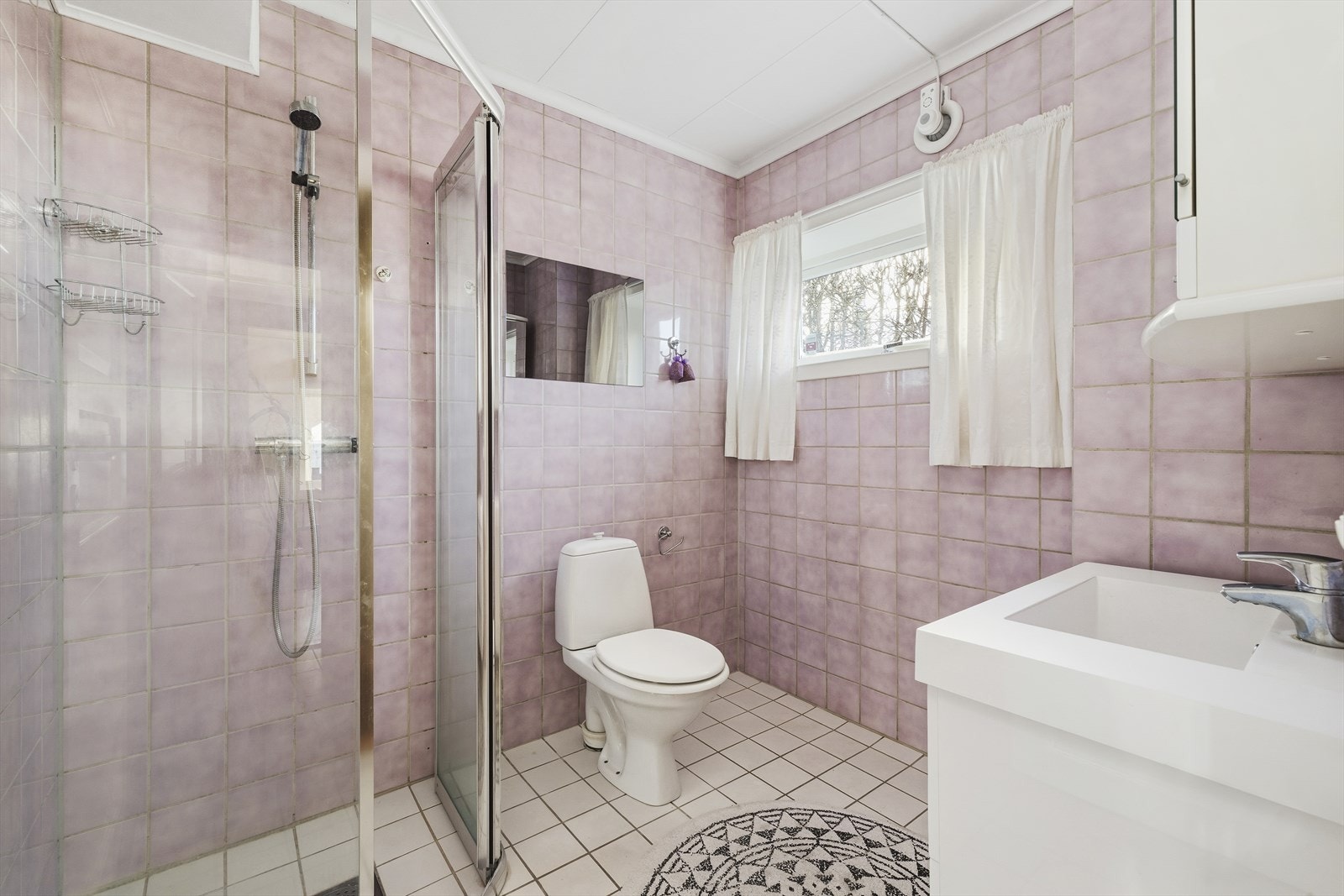 Videre er det et flislagt bad med toalett, dusj og servant. Galleribilde