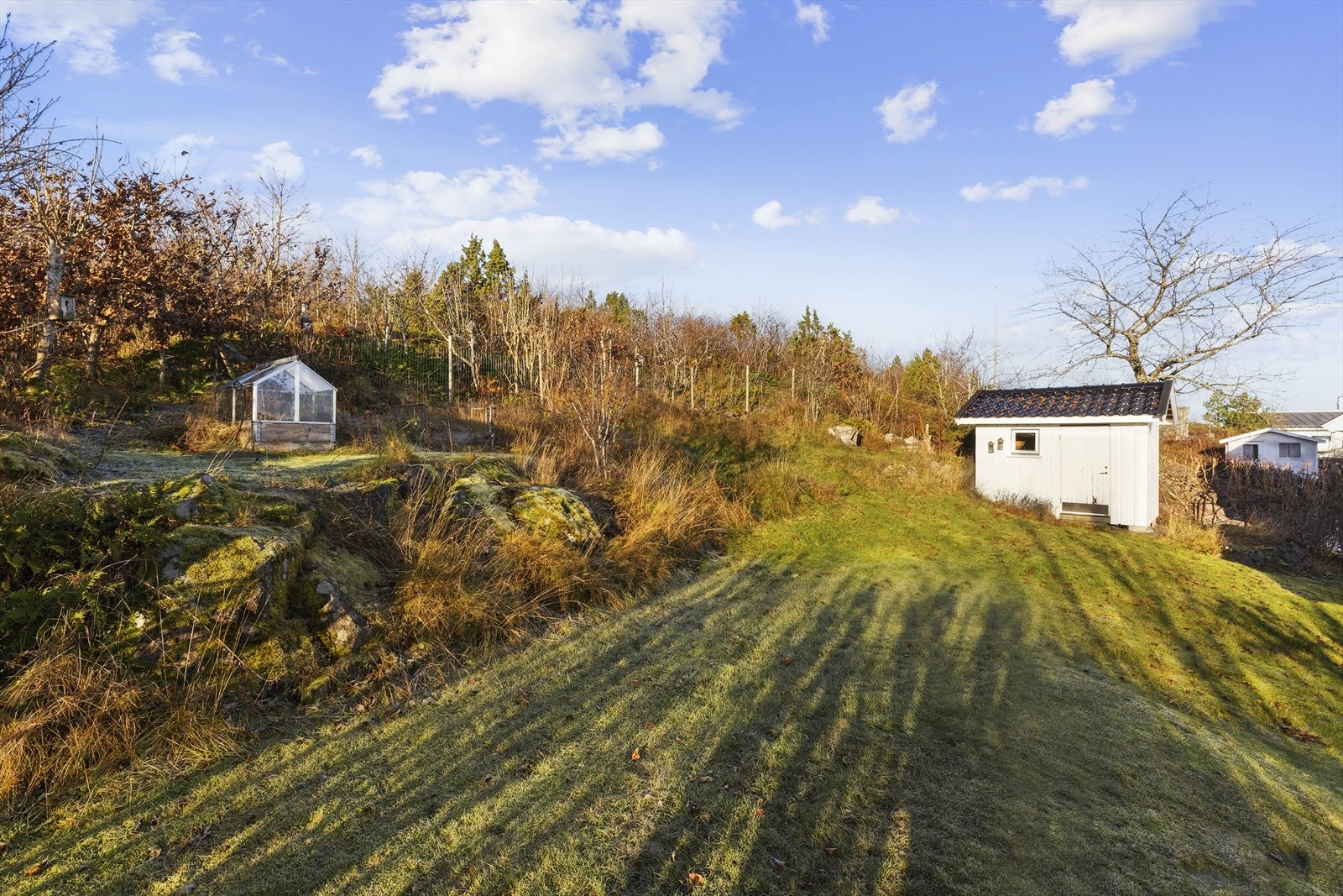 Hagen er anlagt med plen, diverse prydbusker og beplantning, et praktisk drivhus og en utvendig bod/uthus. Galleribilde