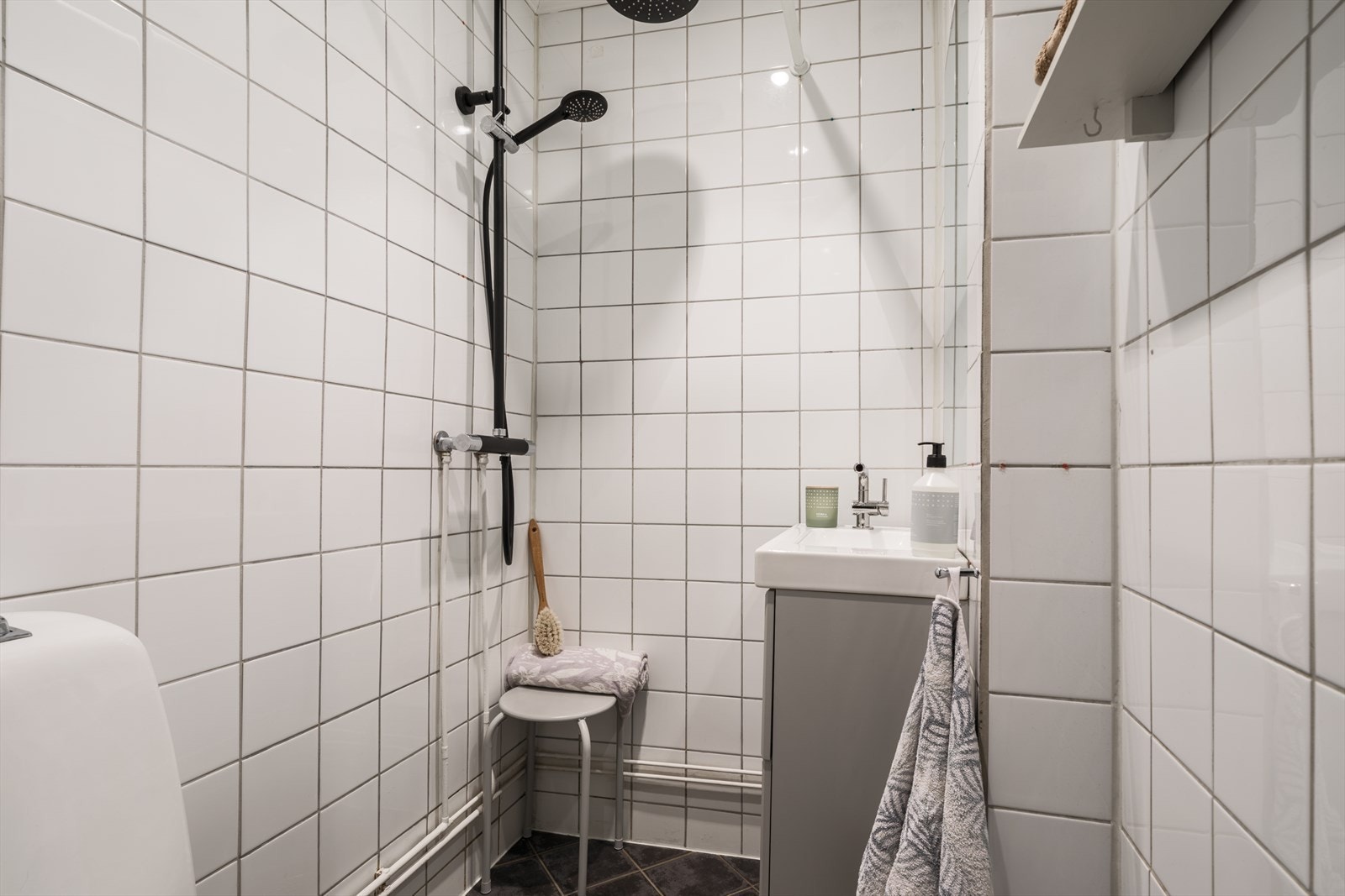 Flislagt bad med lyse fliser på vegger, og mørke på gulv Galleribilde