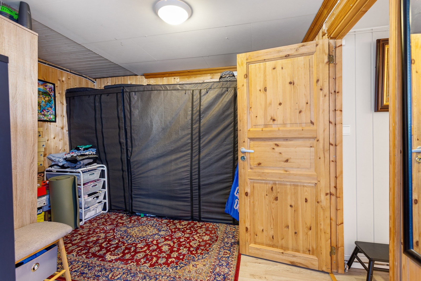 Entré med laminat på gulv, panel på vegger og malte plater i himling Galleribilde