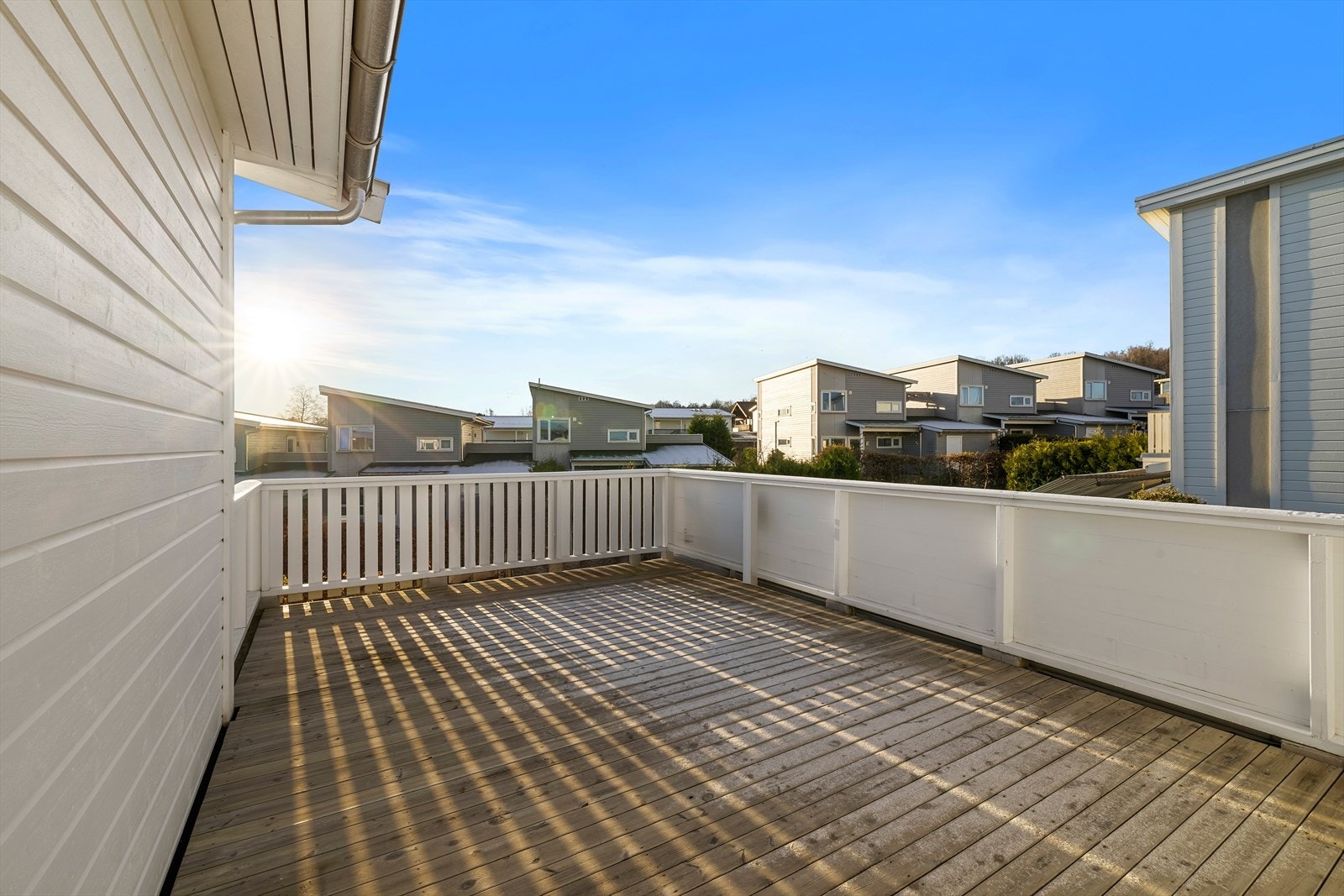 Her er det dekke av tre og terrassen er pent innrammet med rekkverk. Her er det god plass til ønskelig utemøblement og hyggelig beplantning. Galleribilde