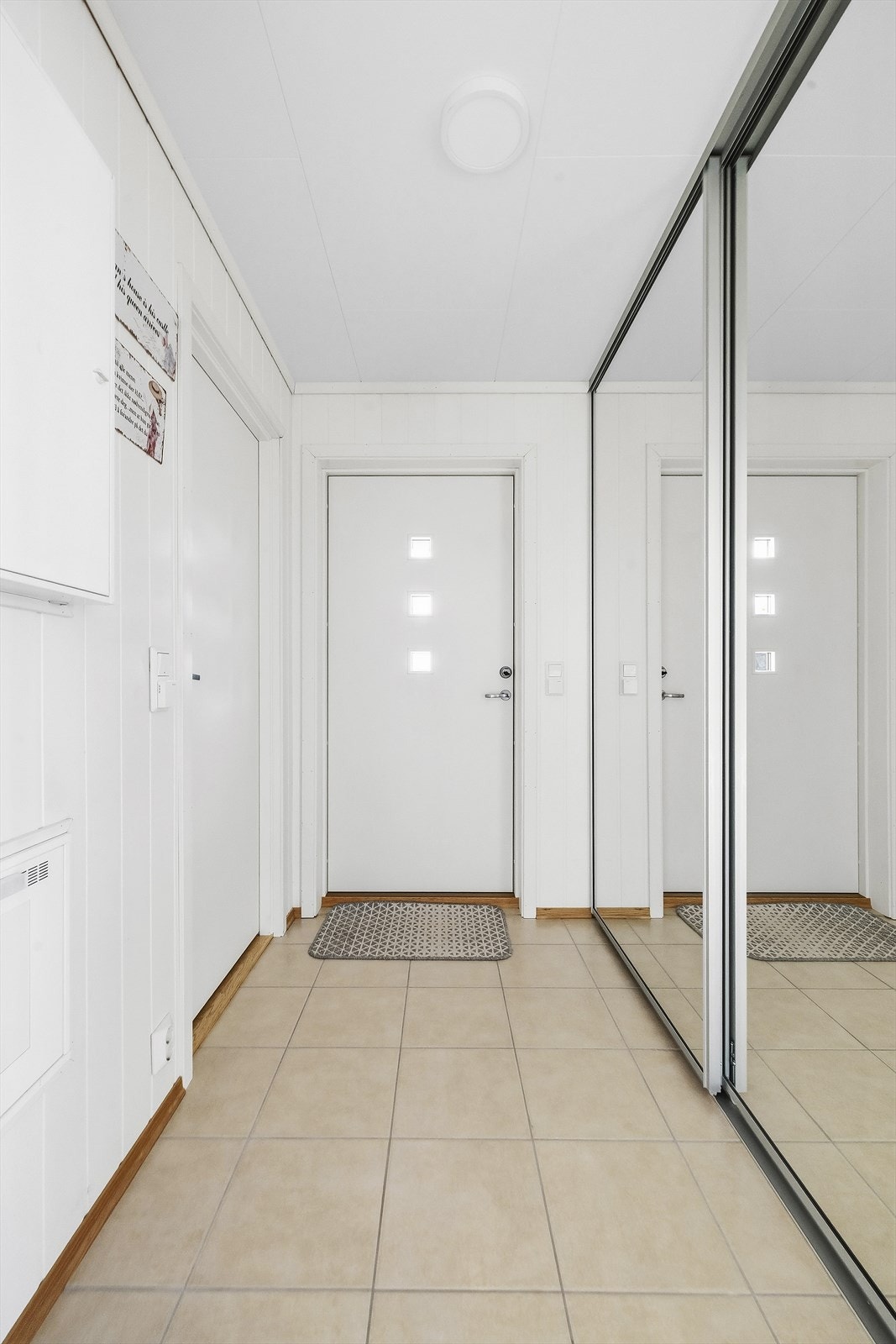 En lys og pent flislagt hall med varmekabler i gulvet ønsker deg velkommen inn. Her er det også god oppbevaringsplass i en takhøy skyvedørsgarderobe med speilfronter. Galleribilde