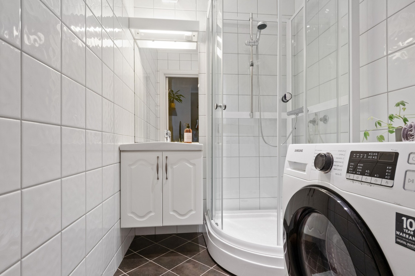 Pent flislagt bad med dusjkabinett fra 2023, varmekabler, servant og opplegg for vaskemaskin. Galleribilde