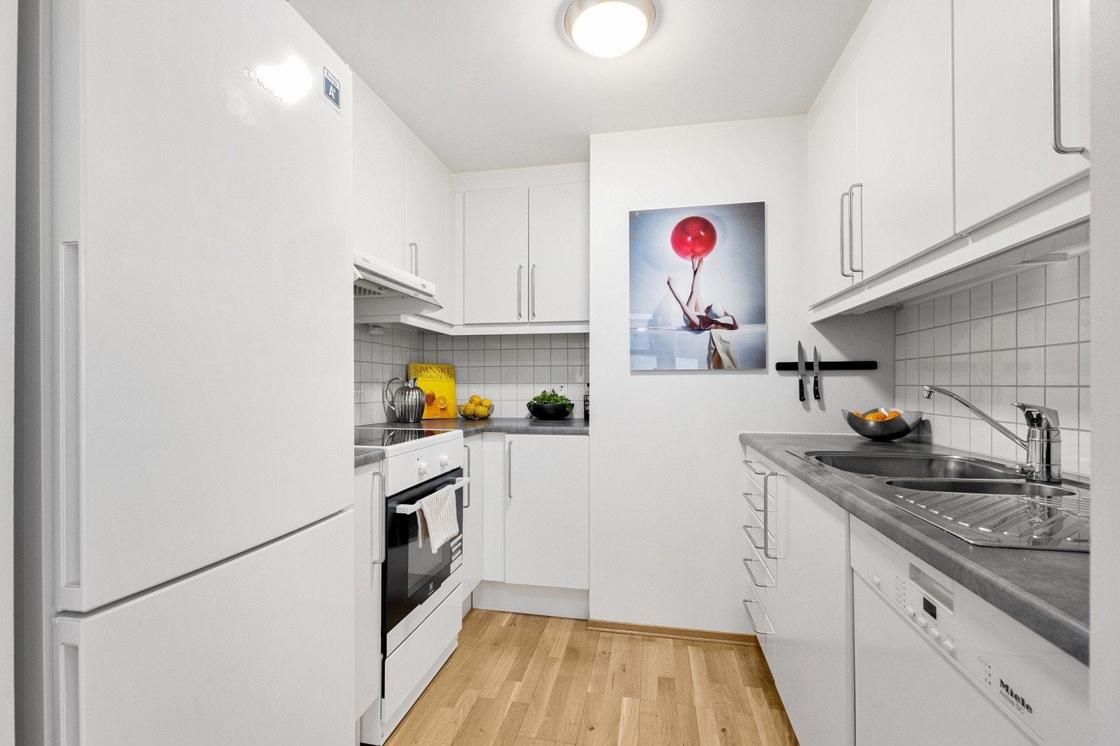 Kjøkken med komfyr, vaskemaskin og kombiskap Galleribilde