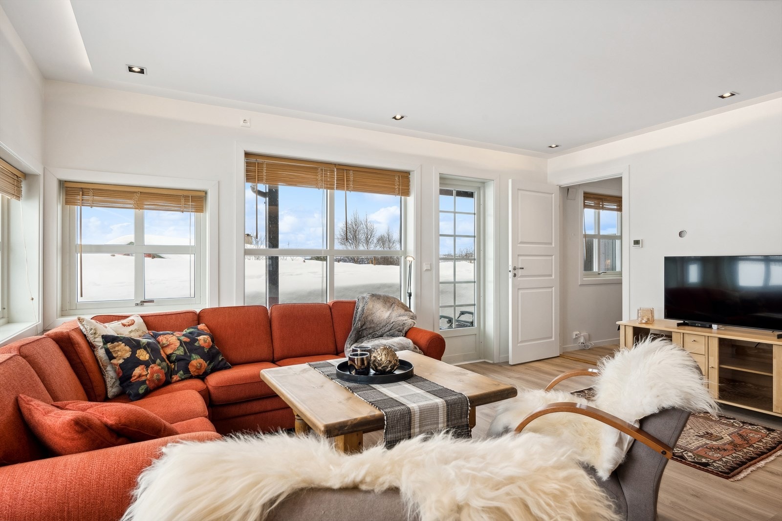 Stuen er romslig og byr på god plass til sofagruppe. Til høyre ser man døren til hovedsoverom med tilhørende dusjbad. Galleribilde