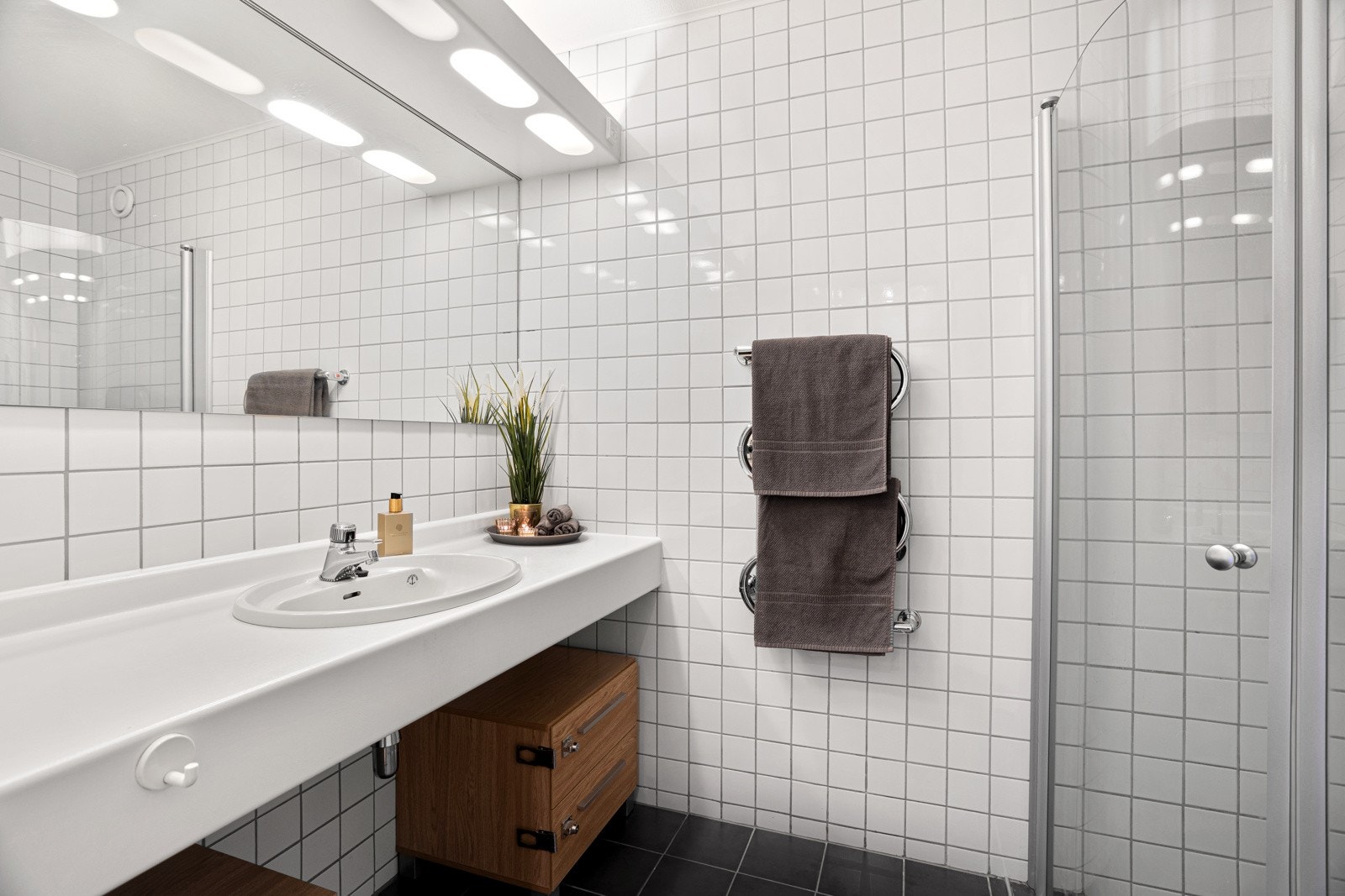 Leiligheten har to fullverdige bad. Bad I - Delikat og tidløst baderom med flislagte gulv og vegger Galleribilde