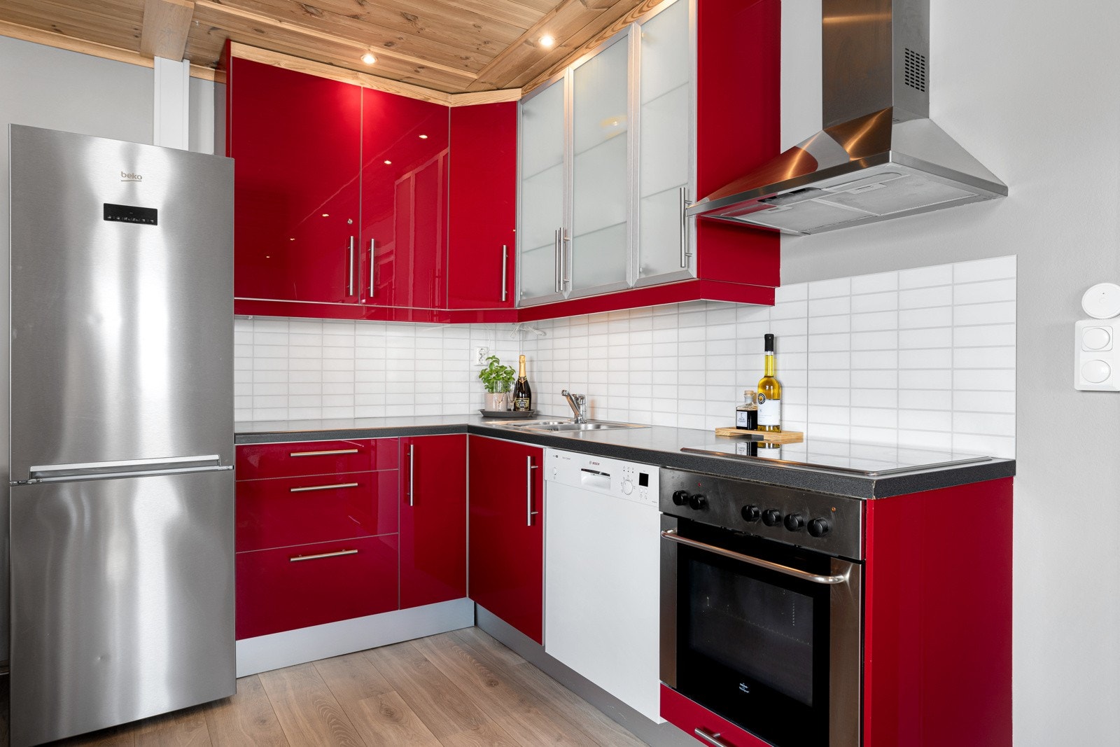 Kjøkkenet inneholder oppvaskmaskin, komfyr, platetopp og kjøleskap med frysedel Galleribilde