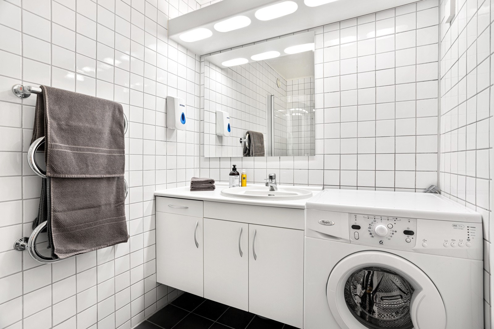 Bad II inneholder servant i innredning, toalett, vaskemaskin og dusjhjørne med glassvegger Galleribilde