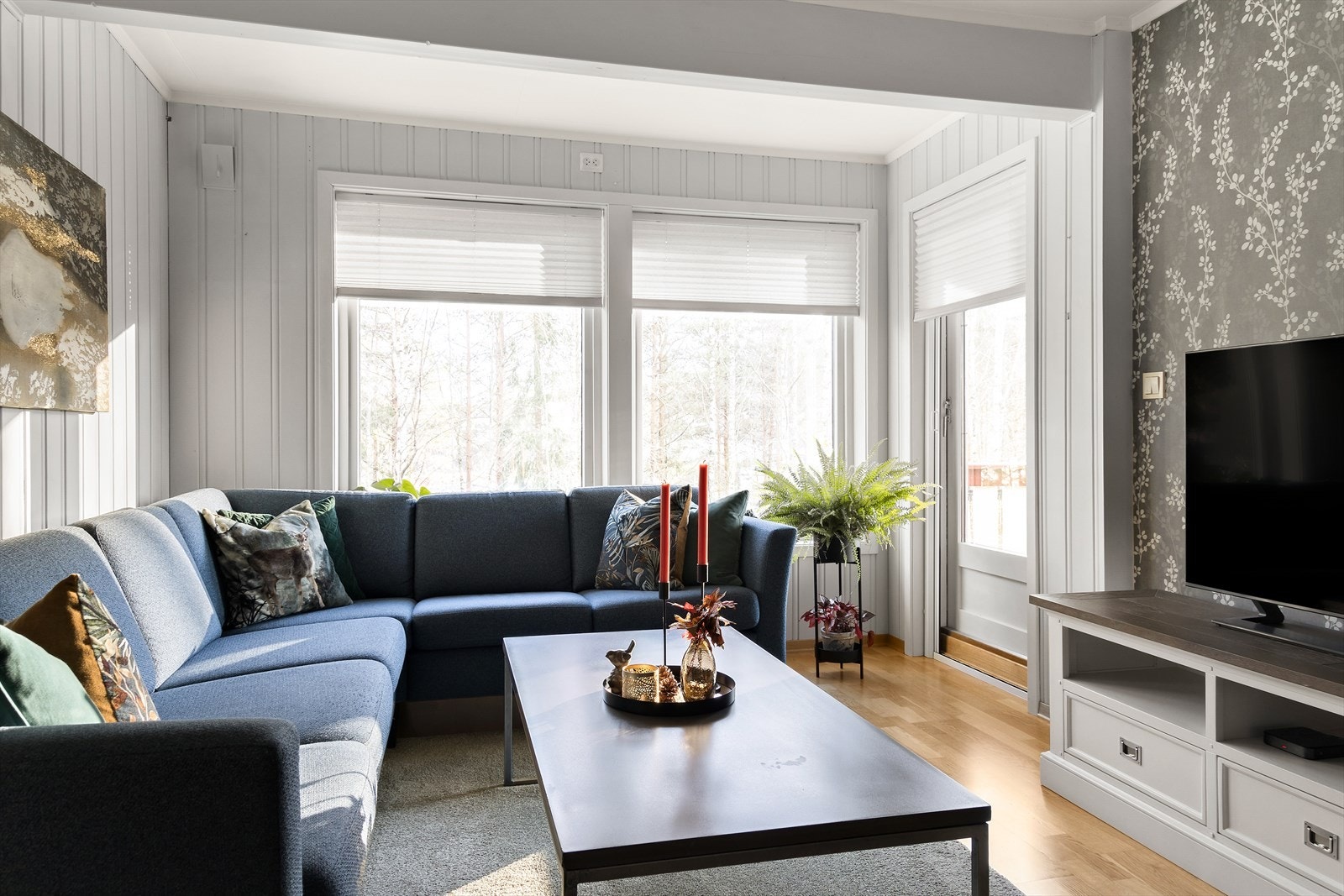 Det er montert pliségardiner på vinduene i stuen. Galleribilde