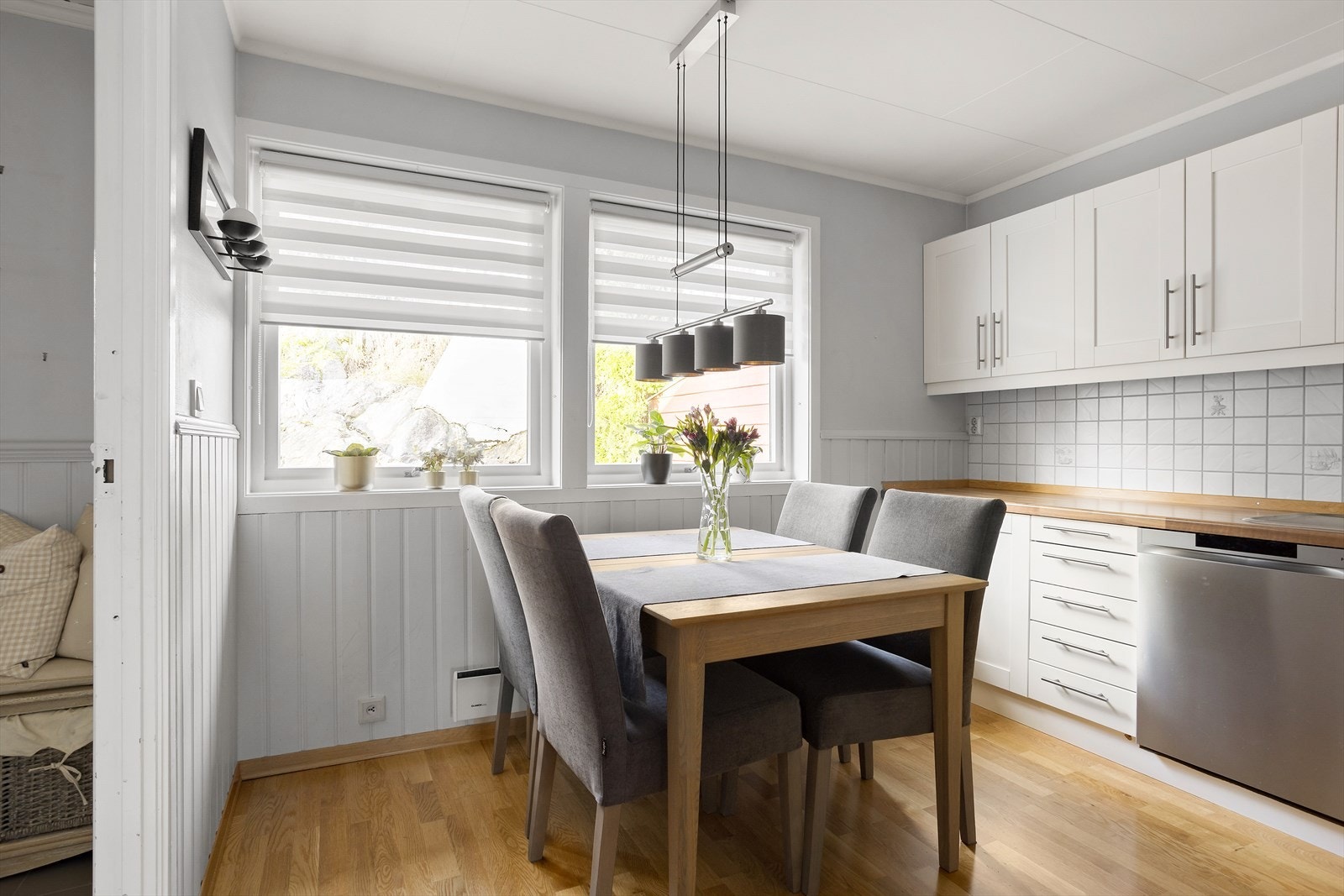 Ved to vinduer er det plass til spisebord, og langs to vegger i praktisk hjørneløsning er det en pen, hvit innredning med oppgraderte overflater fra 2010. Galleribilde