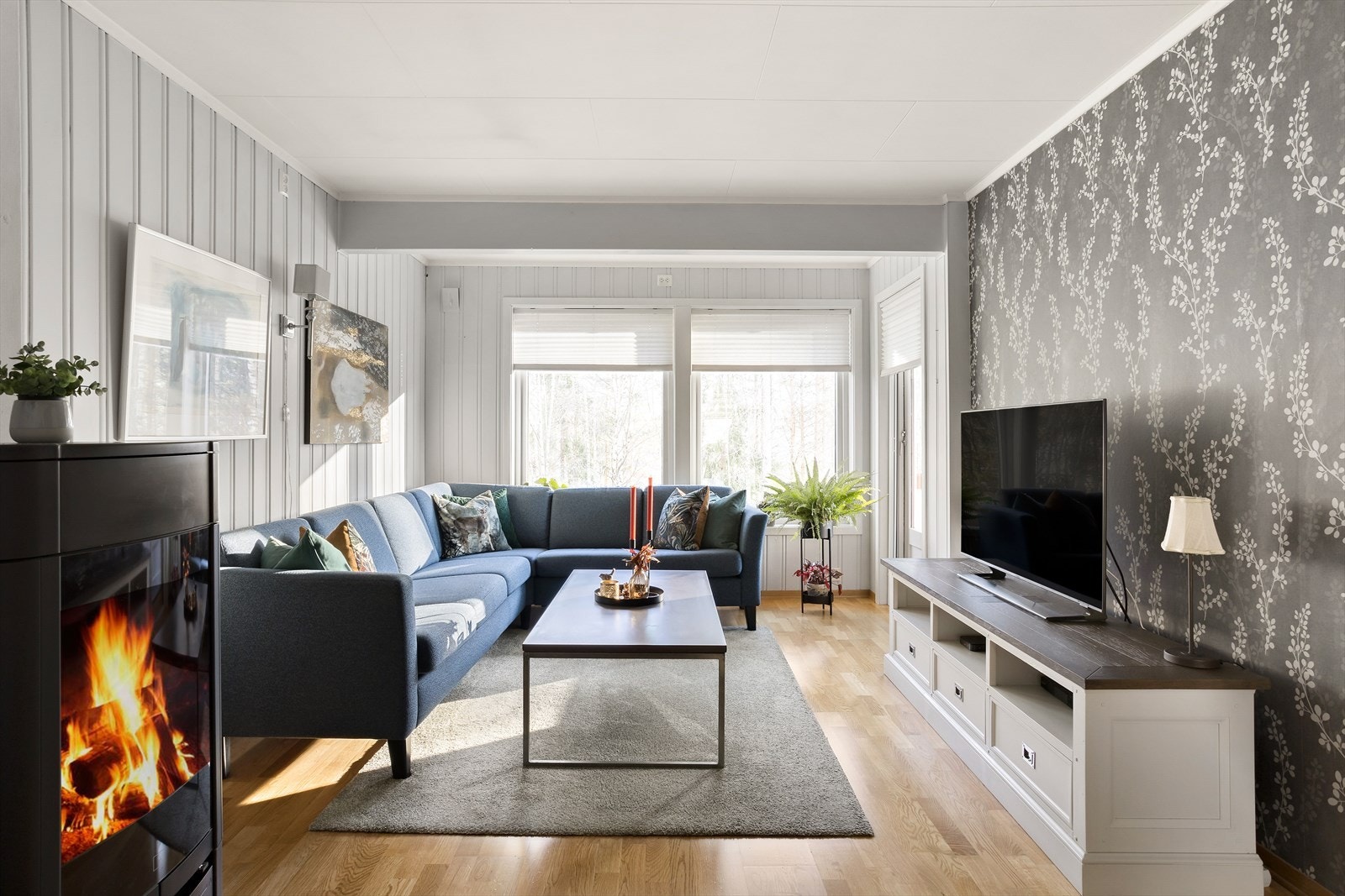 På gulvet er det parkett, mens veggene har en smakfull kombinasjon av malt panel og mønstret tapet i to grå nyanser. Galleribilde