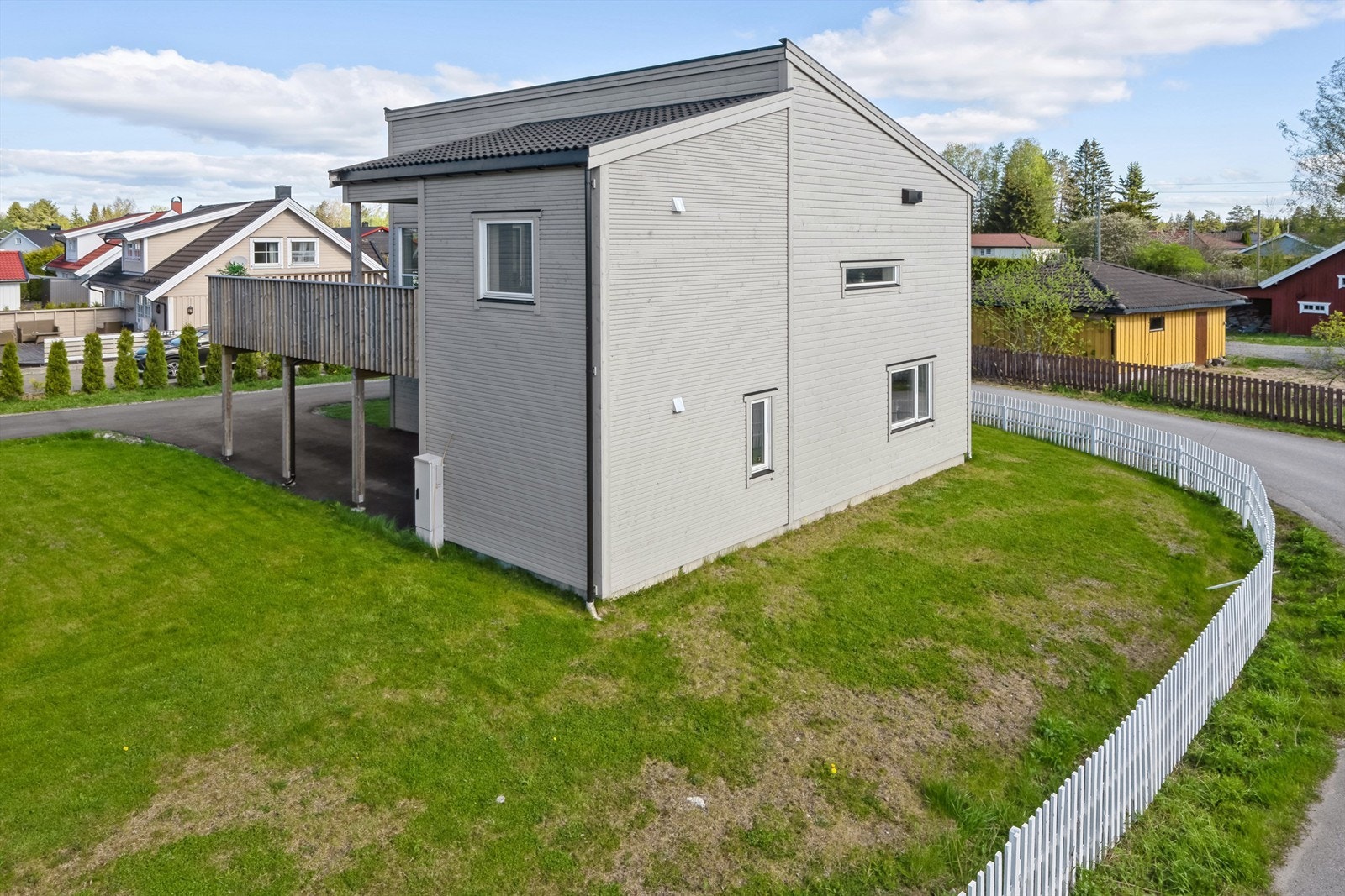 Asfaltert gårdsplass og inngjerdet hage Galleribilde