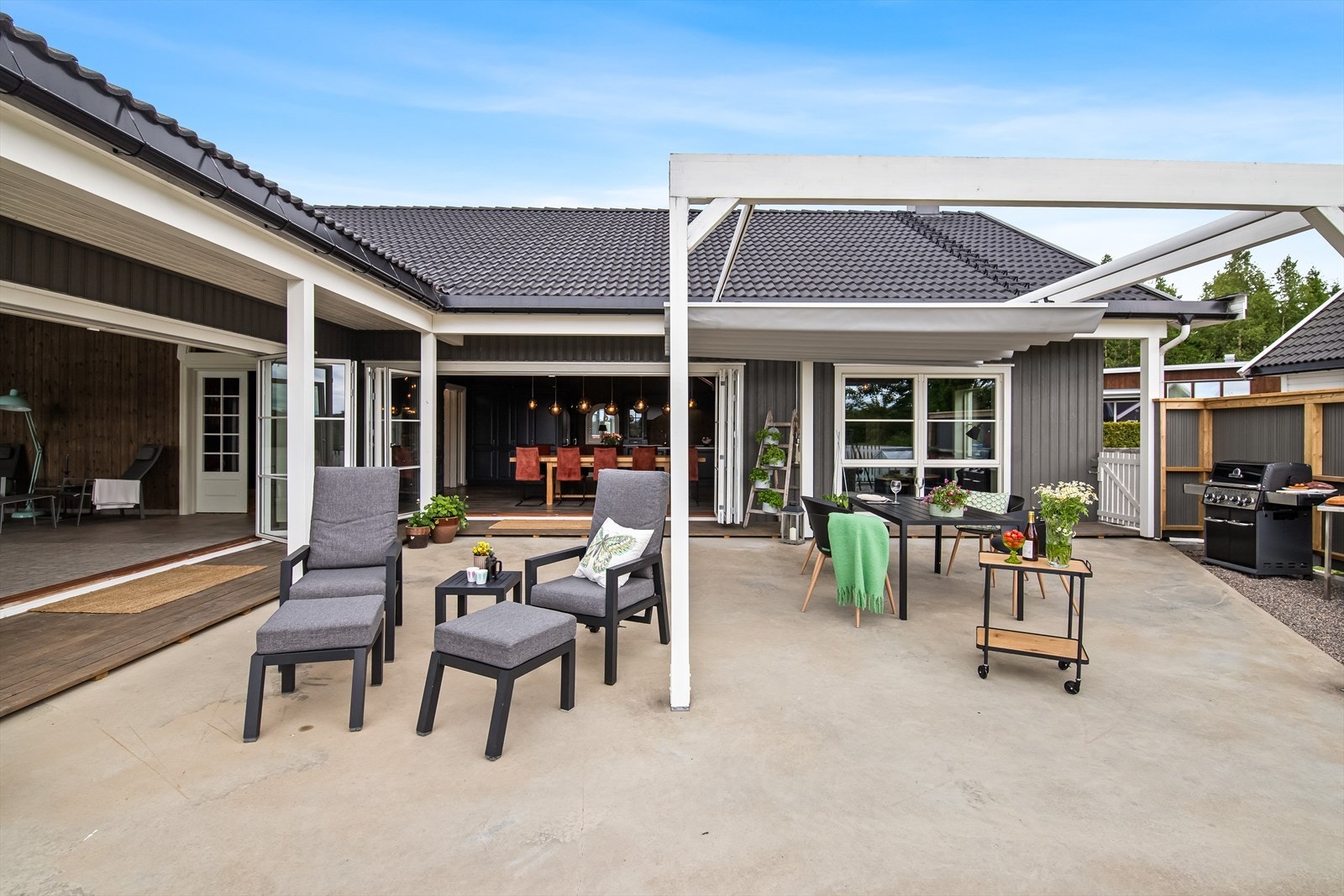 De store foldedørene fra stuen visker ut skille mellom inne og ute, og gjør terrassen til en naturlig forlengelse av oppholdsrommene. Galleribilde