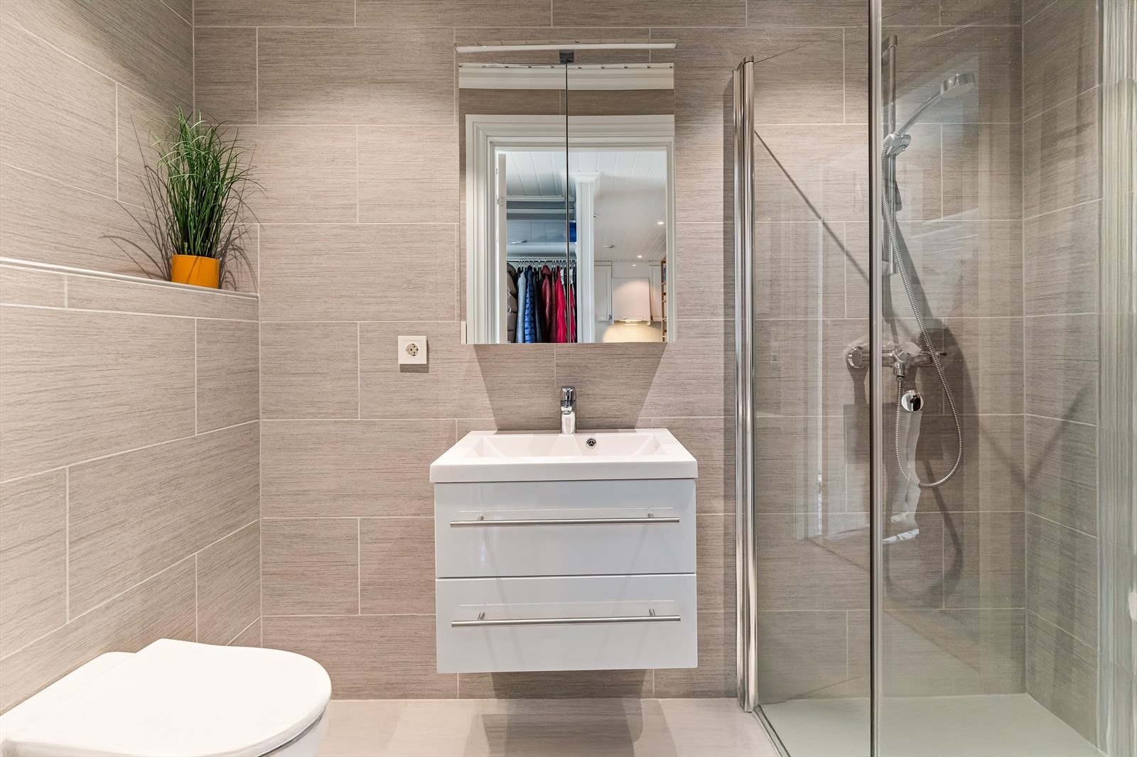 Flislagt bad med dusjnisje, vegghengt toalett og god belysning. Galleribilde