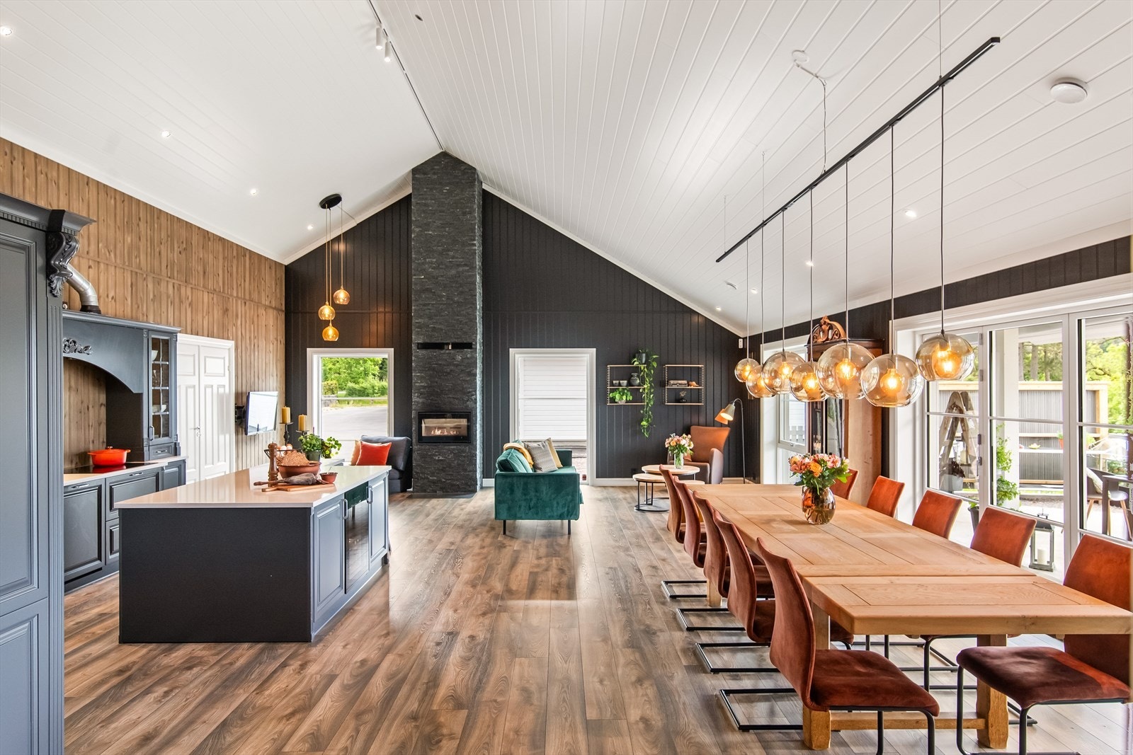 Stue og kjøkken ligger i en åpen og luftig løsning med god plass til stor spisestue og sofakrok ved peisen. Galleribilde