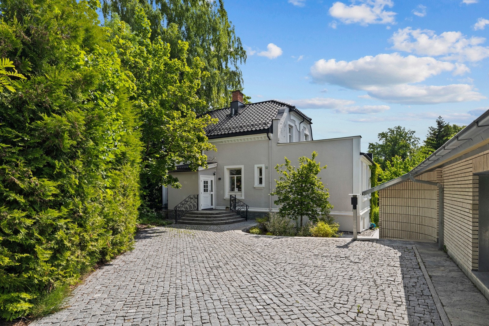 Tomten er pent opparbeidet med brosten belagt gårdsplass. Galleribilde