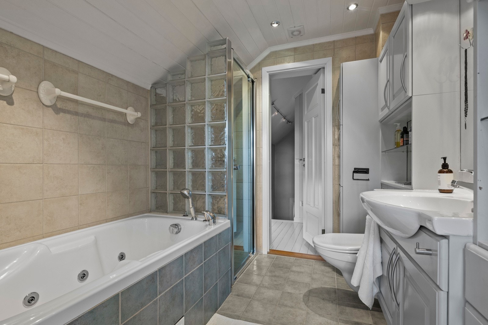 Flislagte veggflater og malt innvendig tak med downlights. Galleribilde