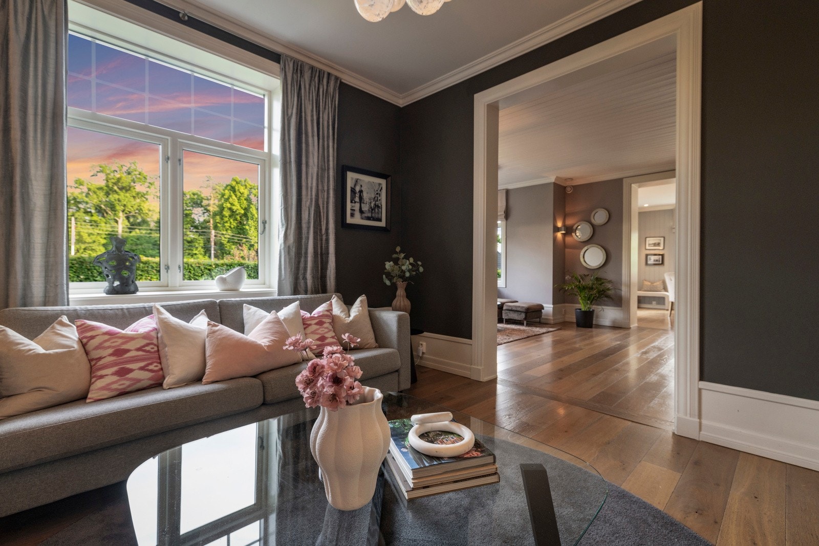 Stilren og lun stue med store vindusflater som rammer inn hagen utenfor - ideelt som TV-stue, bibliotek eller salong. Galleribilde