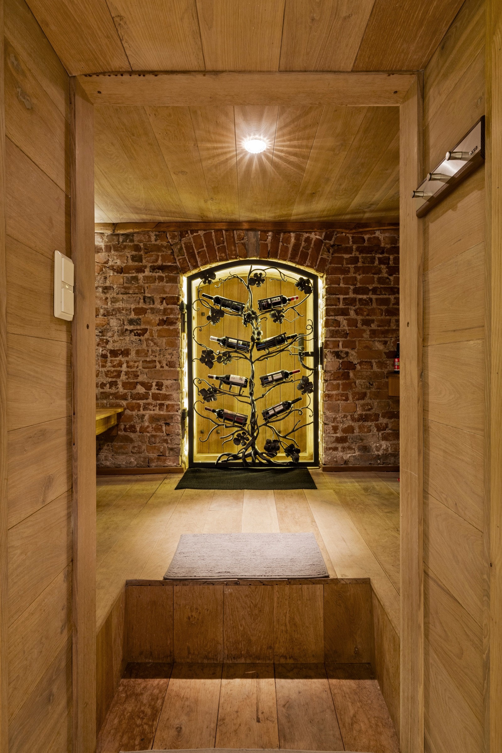 Vinrommet har en lun og rustikk atmosfære, med teglsteinsvegg og innramming i treverk. Galleribilde