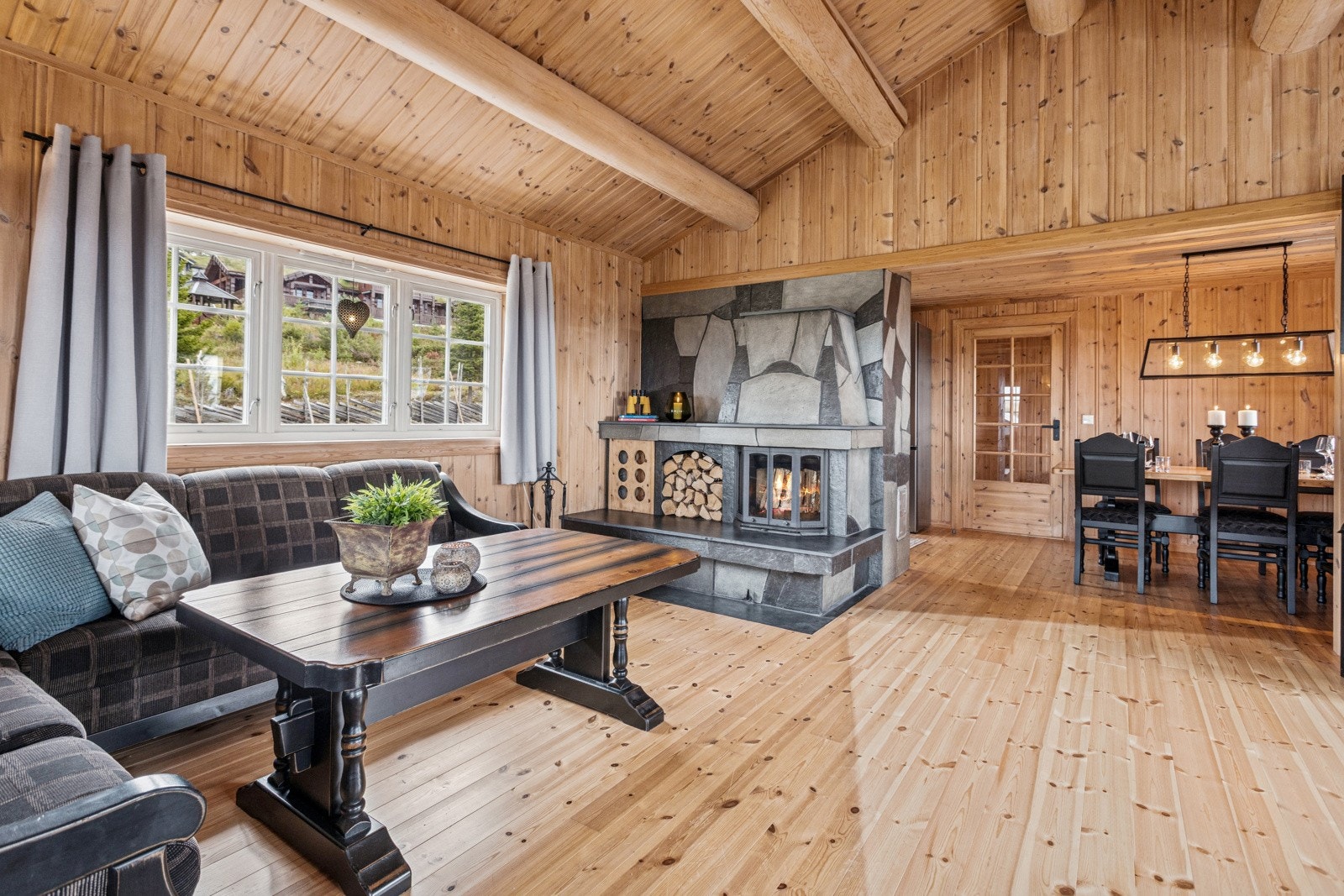 Flott stuedel med god plass for flere sittegrupper. Store vinduer og åpen himling med synlige tømmeråser gir rommet masse naturlig lys og en god romfølelse. Galleribilde