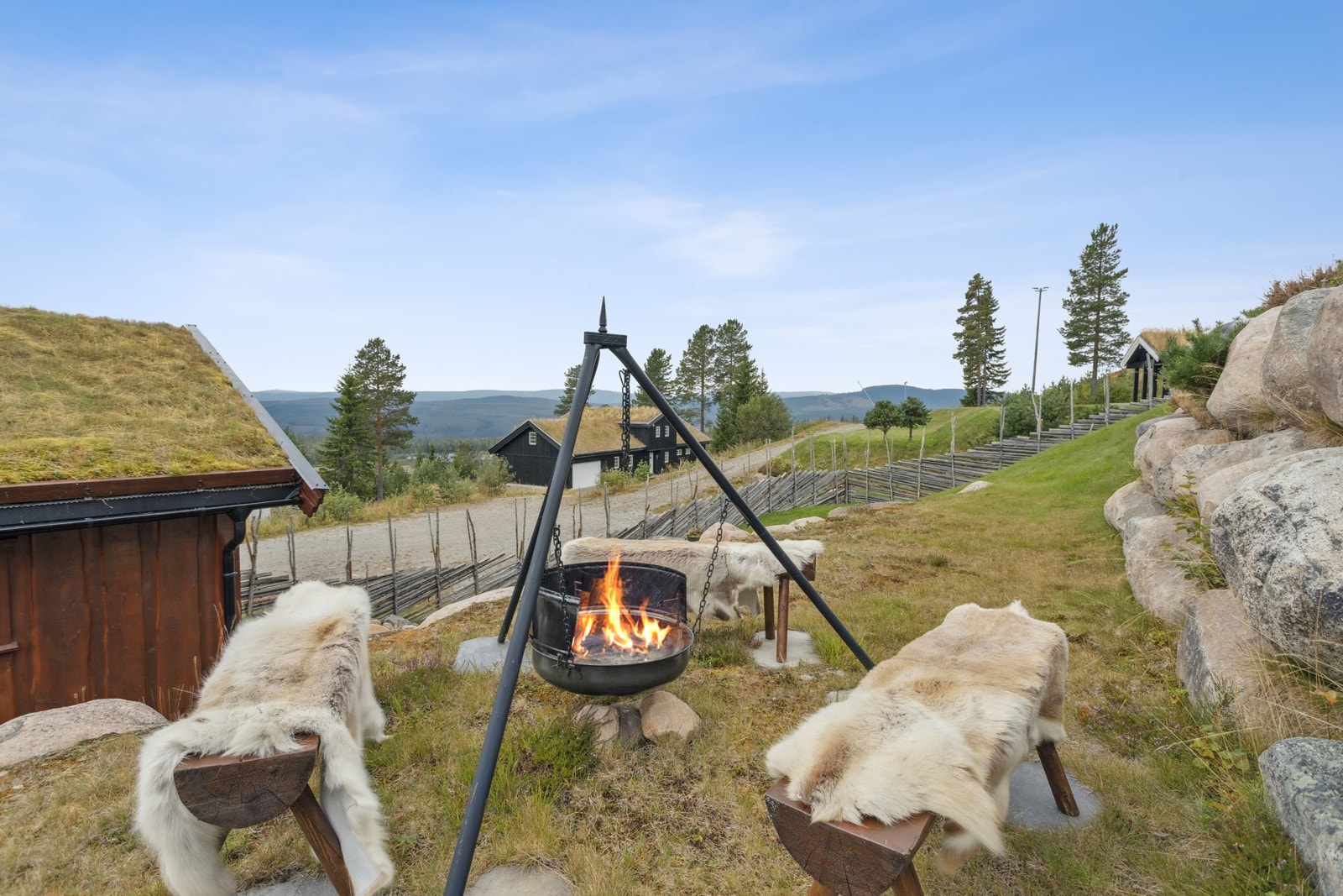 Pent opparbeidet tomt med flere ulike partier med plen, diverse beplantning og steinmurer. Galleribilde