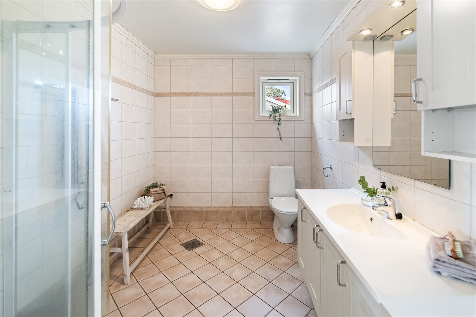 Rommet er helfliset, har gulvvarme og er utstyrt med servantinnredning, dusjhjørne og sokkeltoalett. Galleribilde