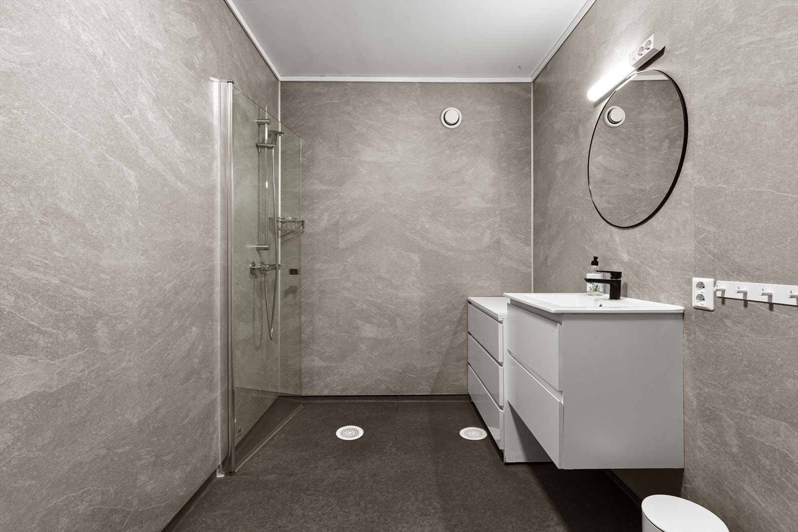 Badet er innreia med nedfelt servant, toalett og dusjvegger/hjørne Galleribilde