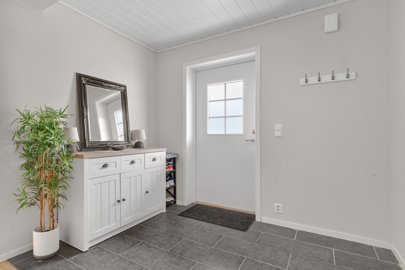 Stort inngangsparti med flislagt golv og god plass til å hengje frå seg yttertøy Galleribilde