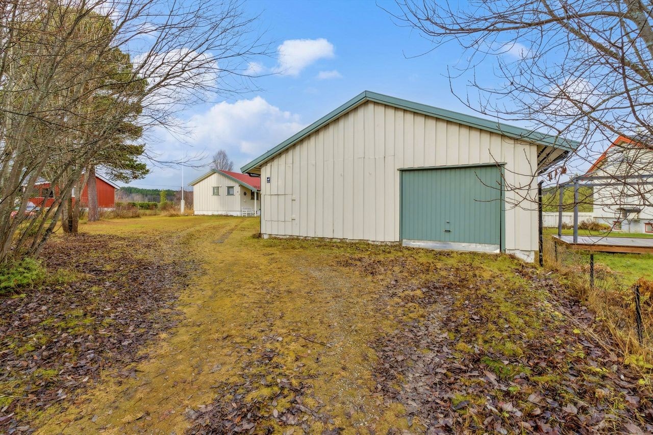 Den romslige garasjen har vippeport i tre og tilbyr gode lagringsmuligheter. Galleribilde