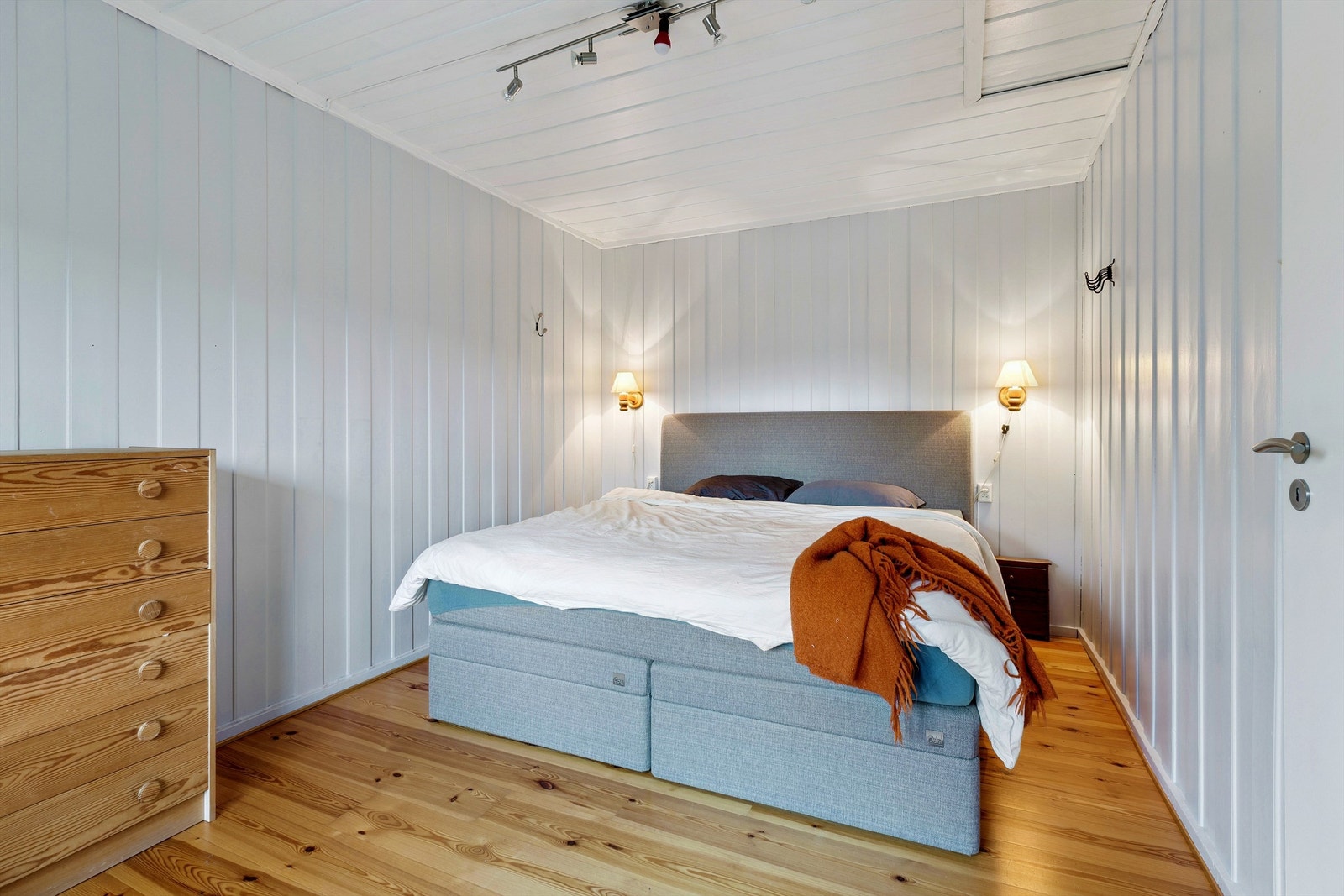 Hovedsoverommet i første etasje har tregulv og malt panel på veggene. Galleribilde