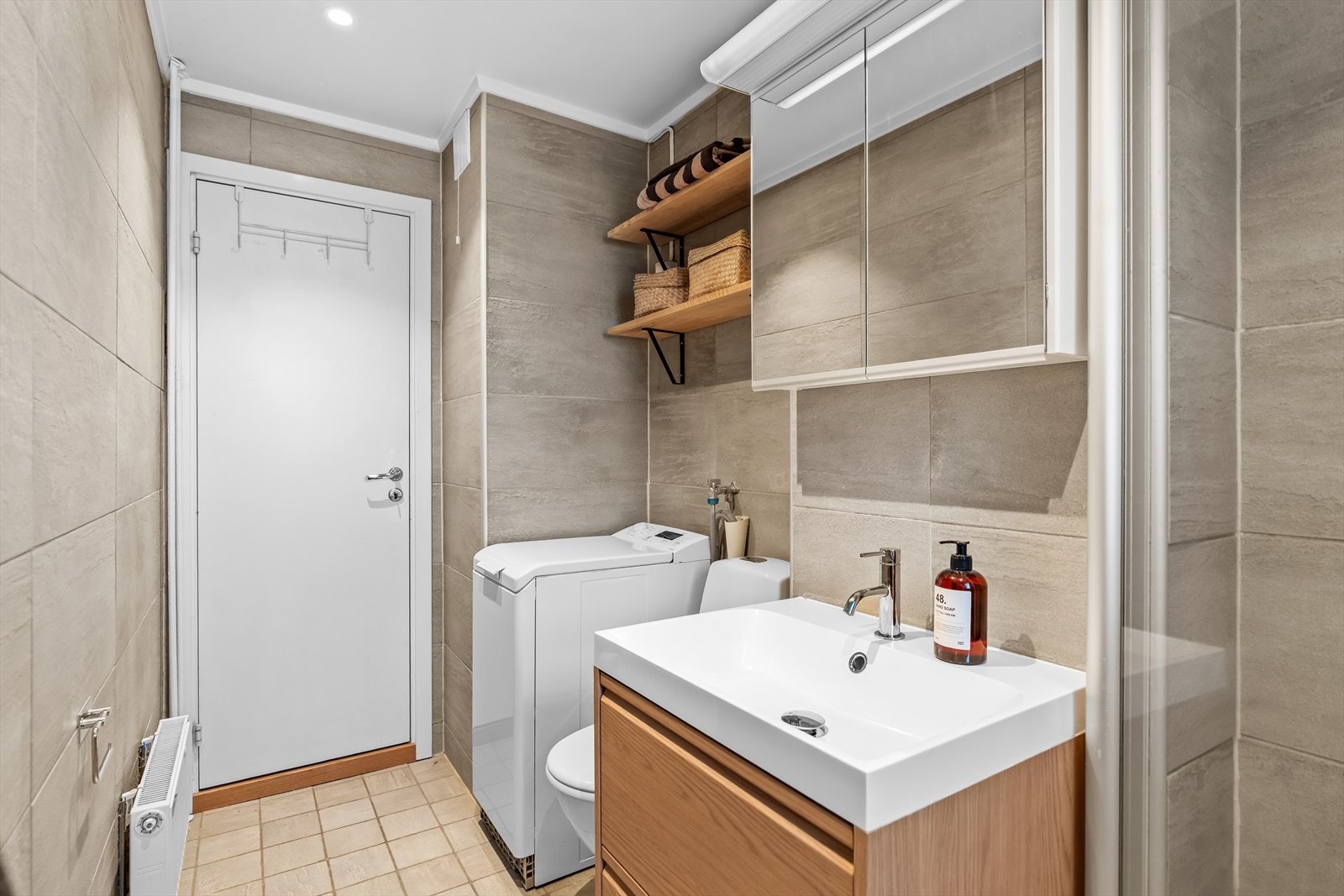 Badet har gulvstående toalett, dusj og opplegg for vaskemaskin. Et vindu sørger for ekstra lys og luftemuligheter. Galleribilde