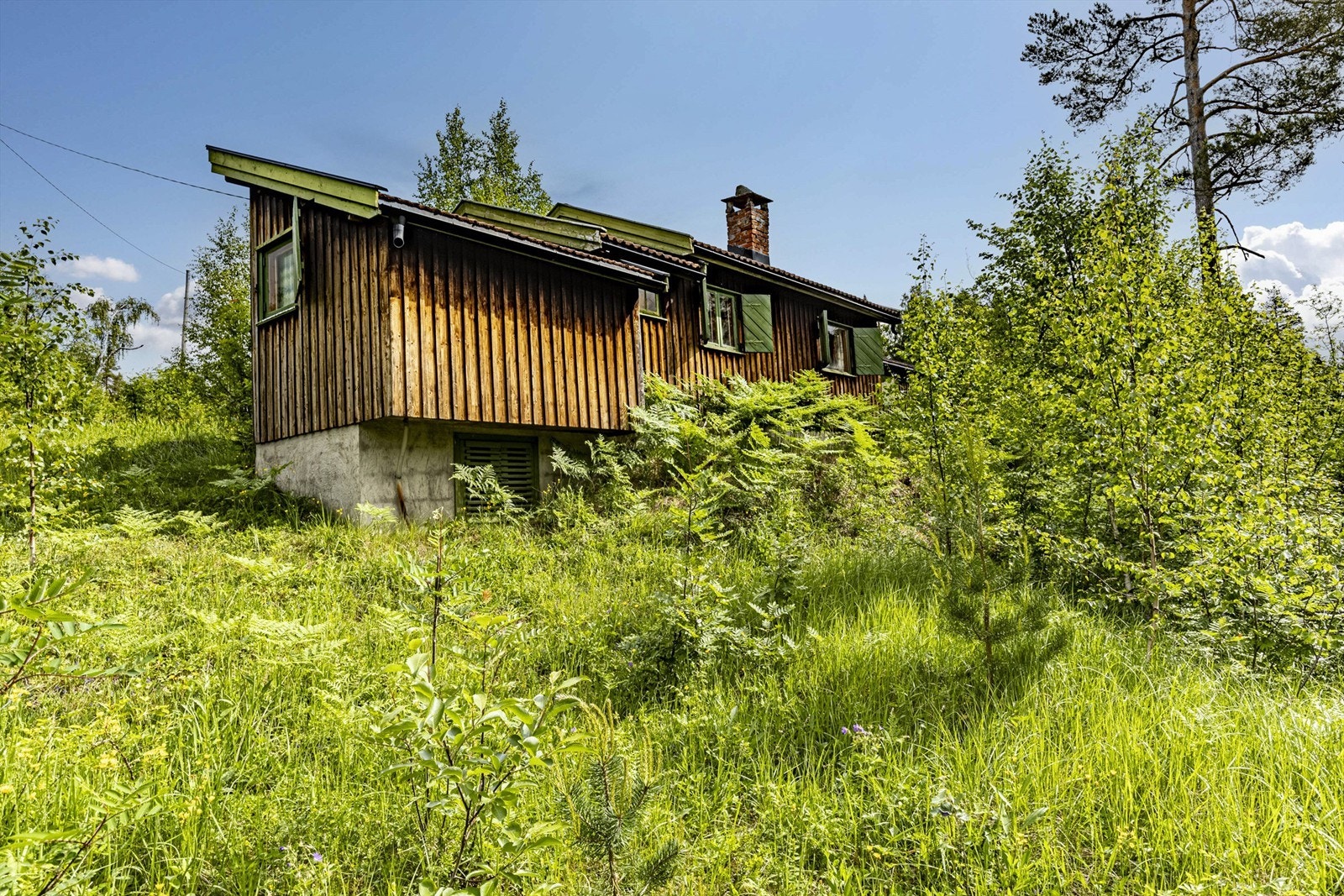 Hytta har en frittstående enkel garasje Galleribilde