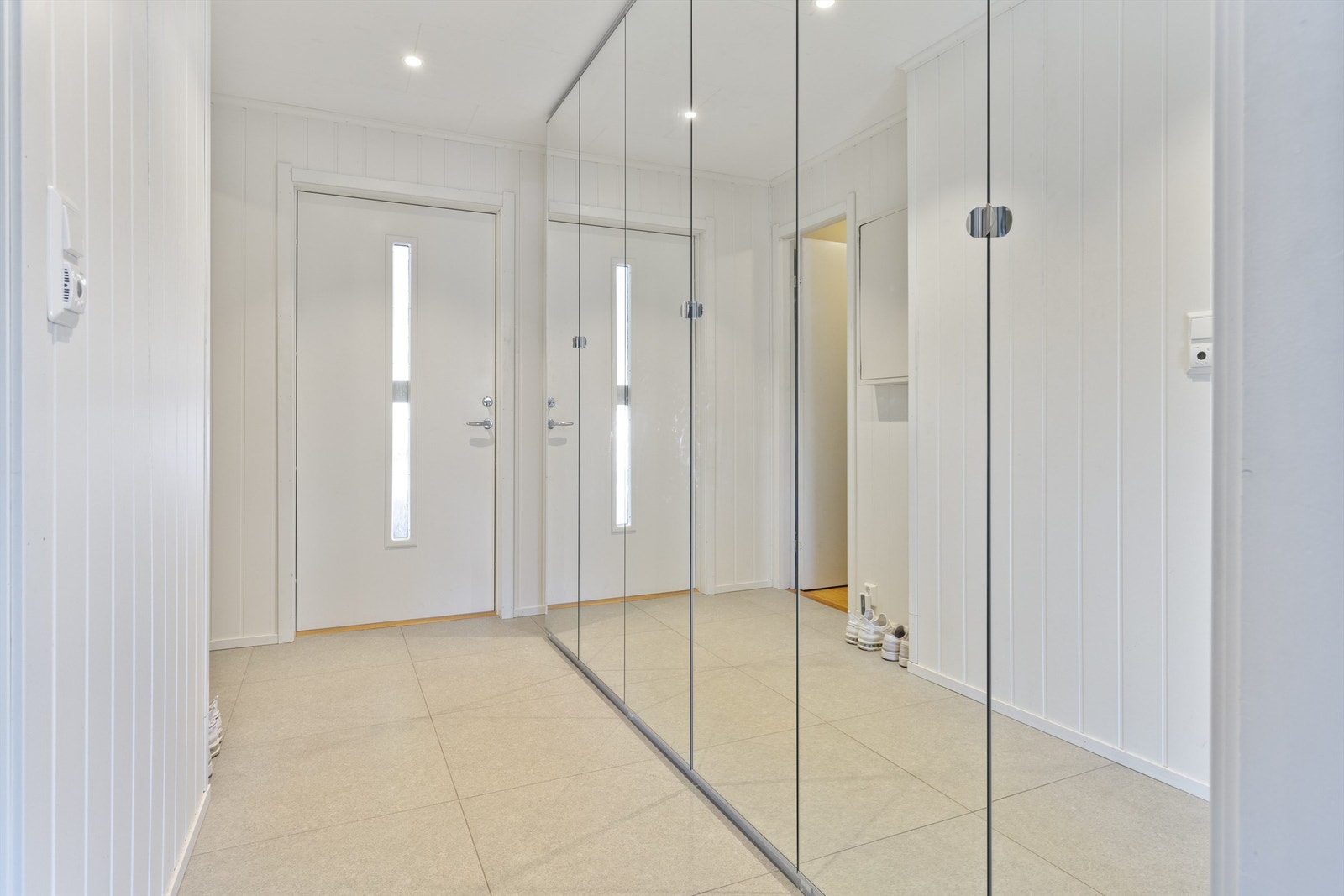 Entré med fliser på gulv, panelplater på vegger og plater i himling Galleribilde