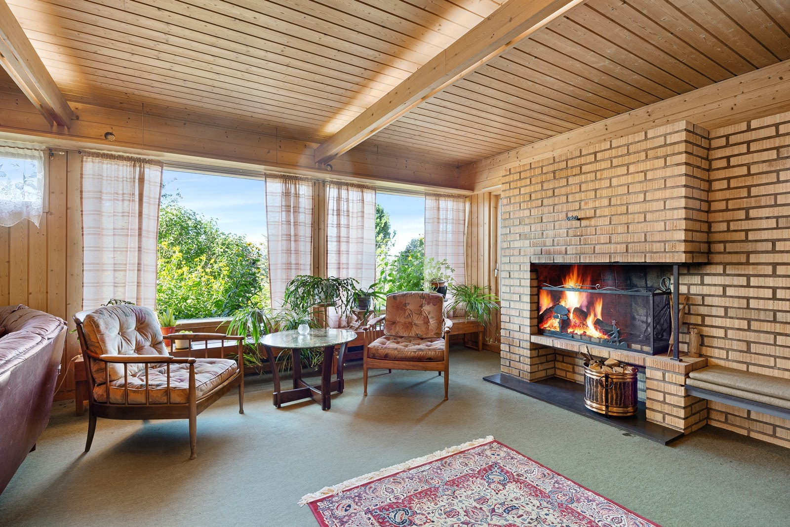 Med store vindusflater som slipper naturen inn og en trivelig peis så ligger alt til rette for stor trivsel i stuen. Galleribilde