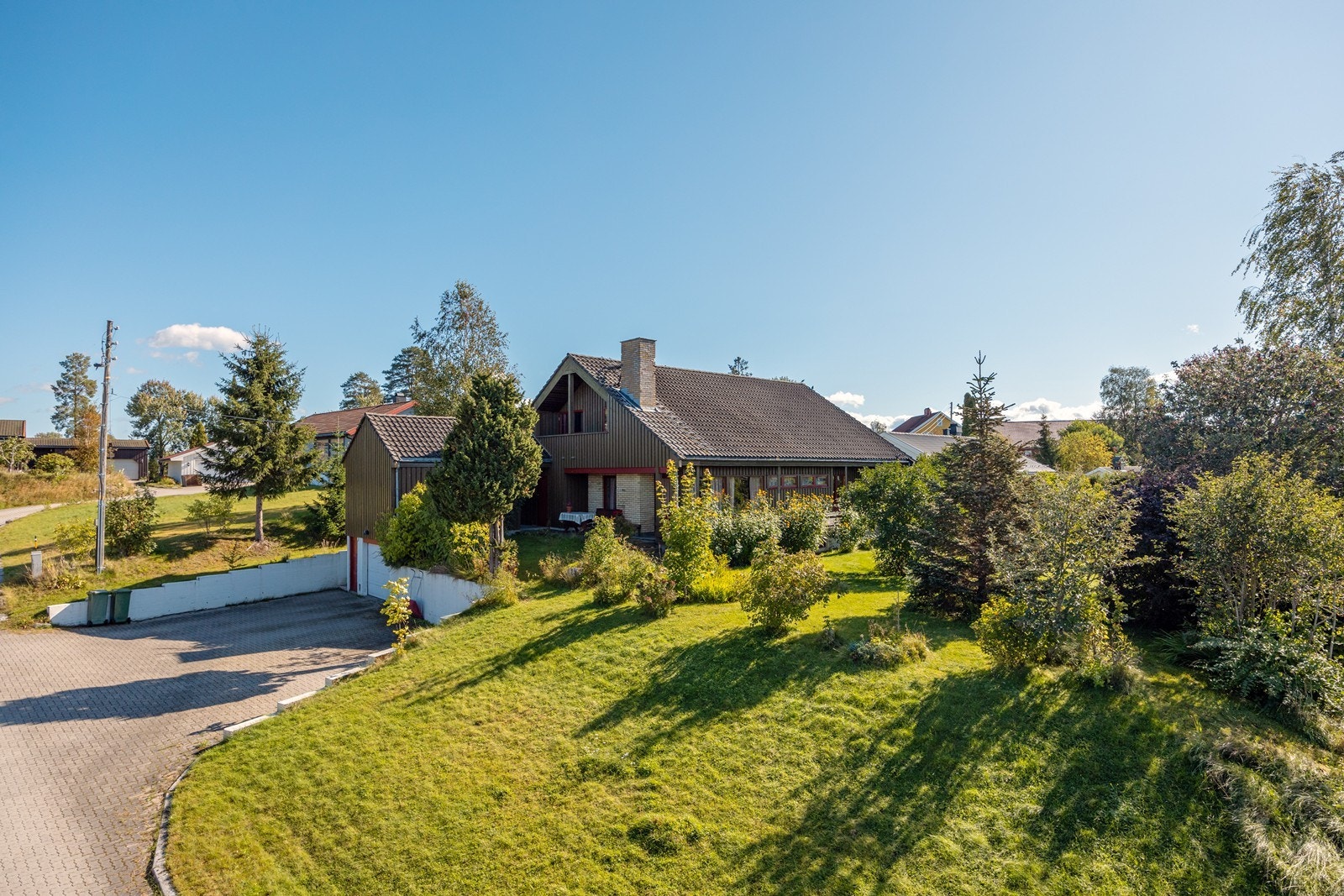 Den store tomten er frodig med gode plenarealer og steinlagt gårdsplass. Galleribilde