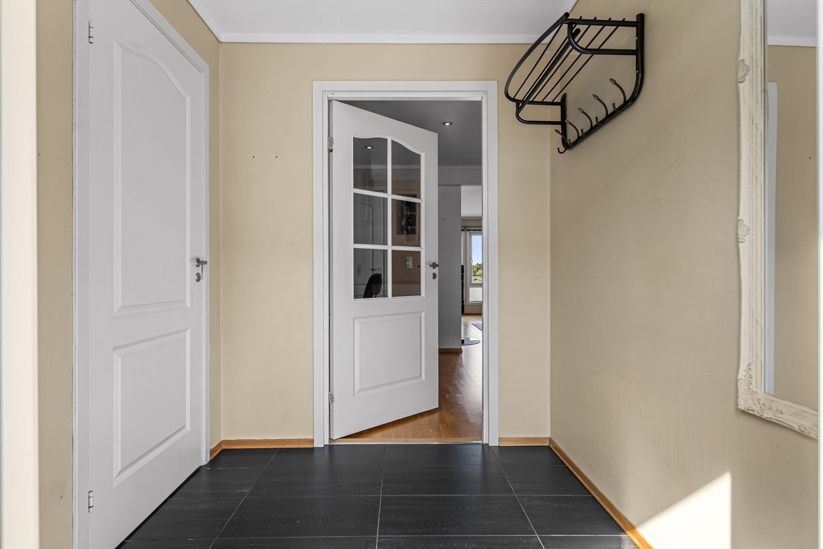 En hyggelig og flislagt entré ønsker deg velkommen inn. Her er det fint plass til oppheng av yttertøy og plassering av sko som er i daglig bruk. Galleribilde