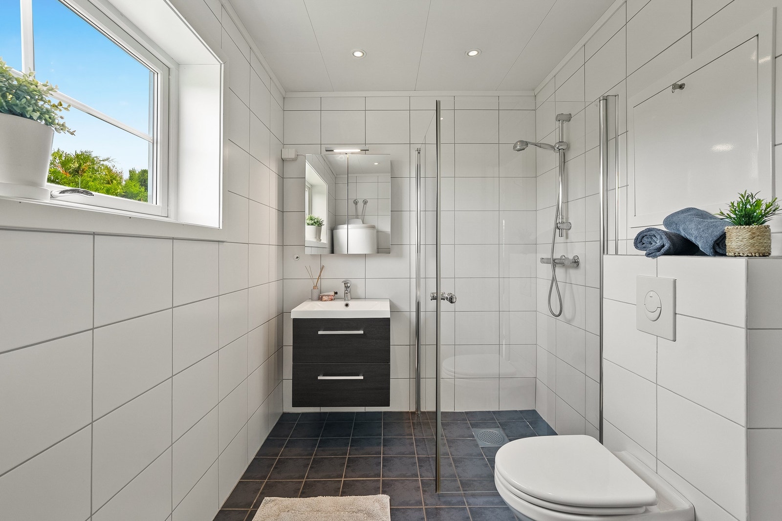 1. etasje har lyst pent flislagt bad fra byggeår med himling av himlingsplater med downlights. Galleribilde