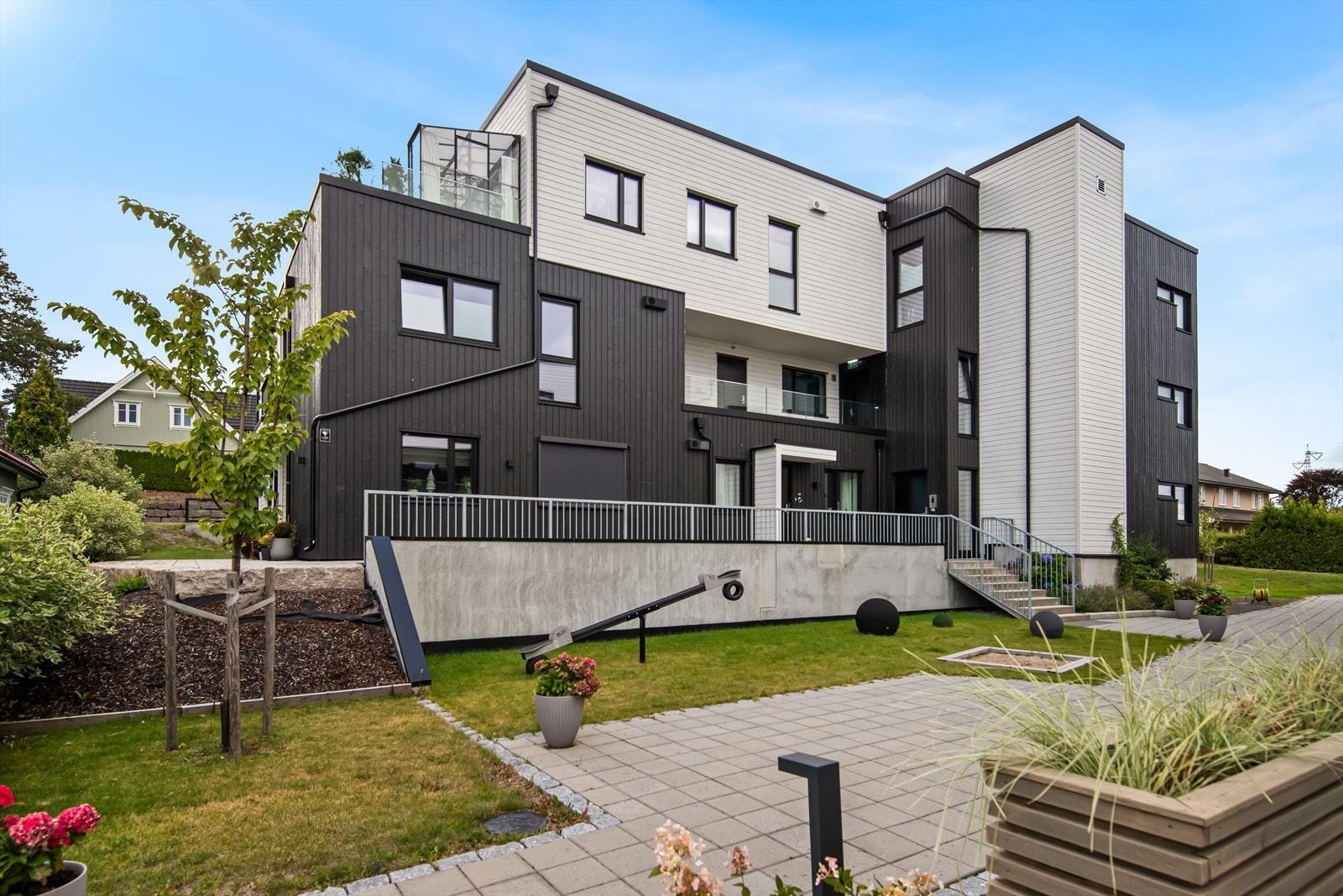 Nyt et sjarmerende uteområde som vil glede deg med sin lekenhet og moderne struktur. Her finner du herlige lekeapparater, en velstelt plen og blomster som skaper en idyllisk atmosfære. Galleribilde