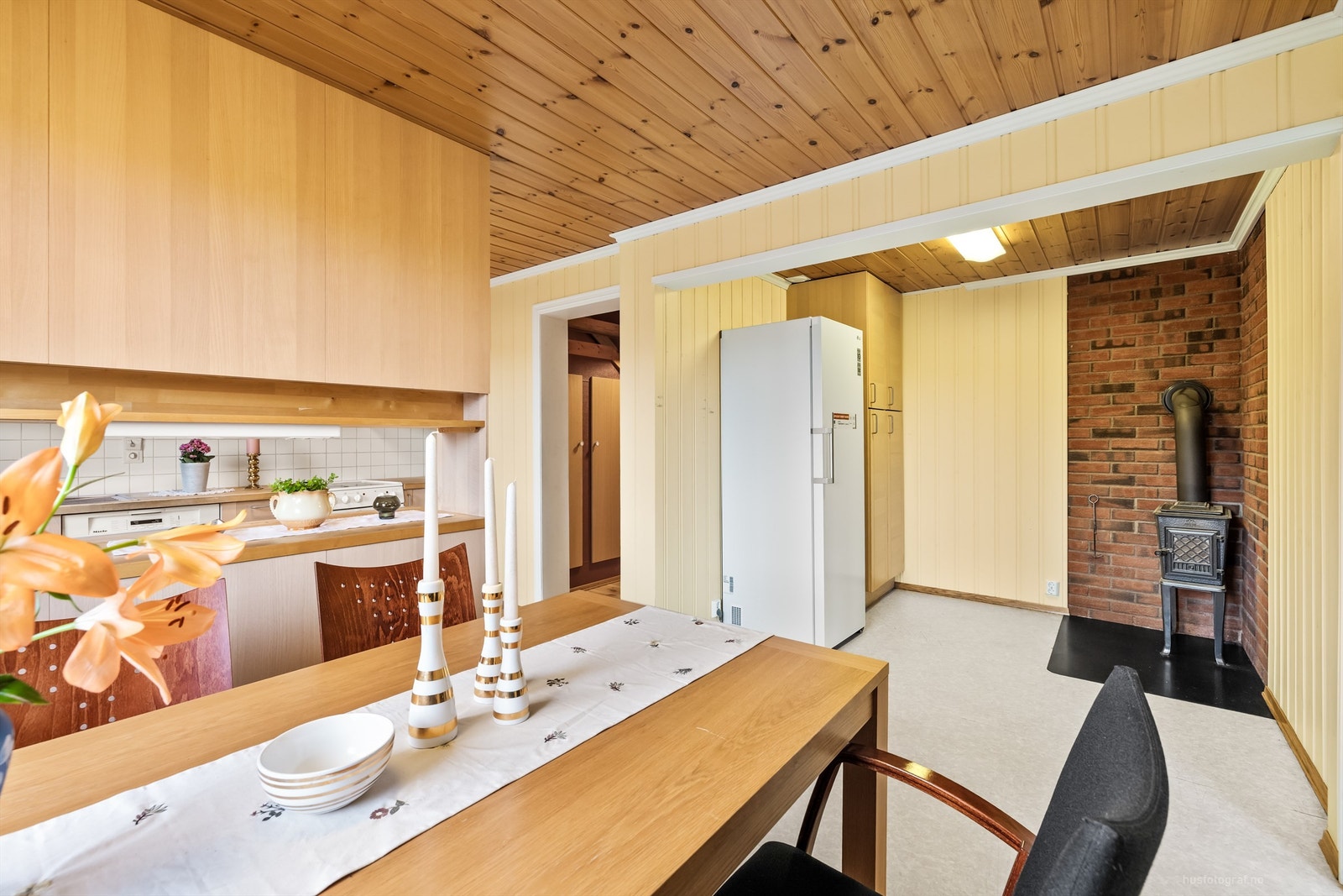 Frittstående vedovn med plate på gulv og murvegger på kjøkkenet Galleribilde