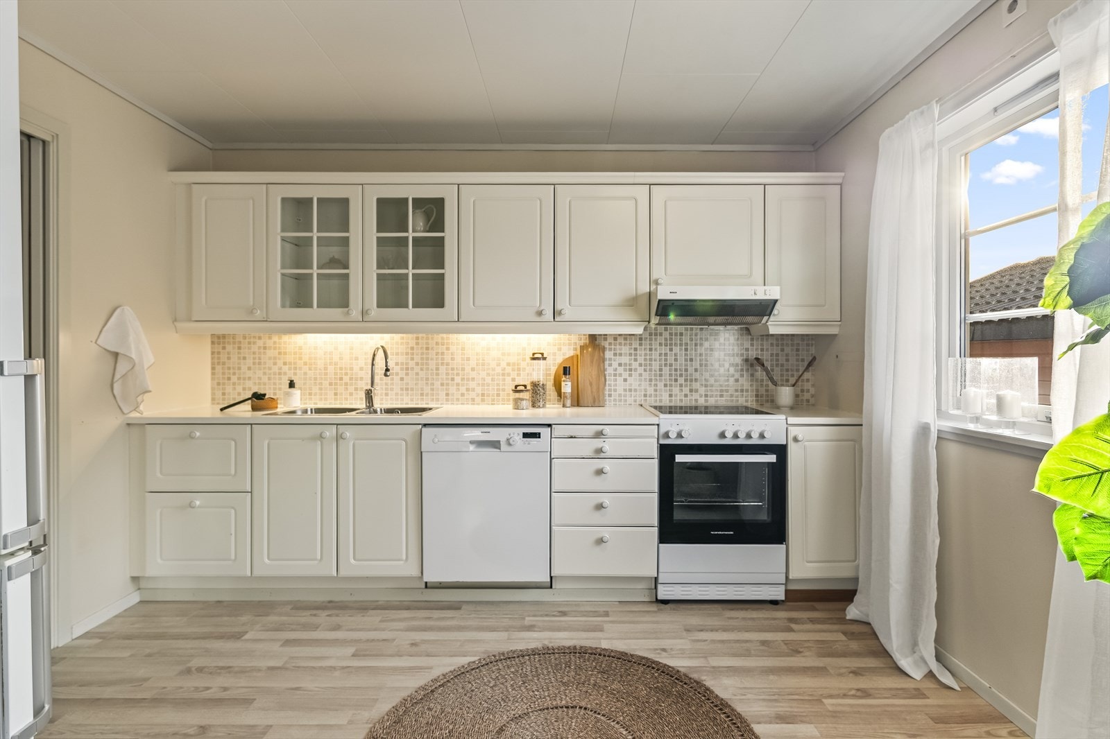 Kjøkkeneinnredningen er fra byggeår og har lyse, profilerte fronter. Galleribilde