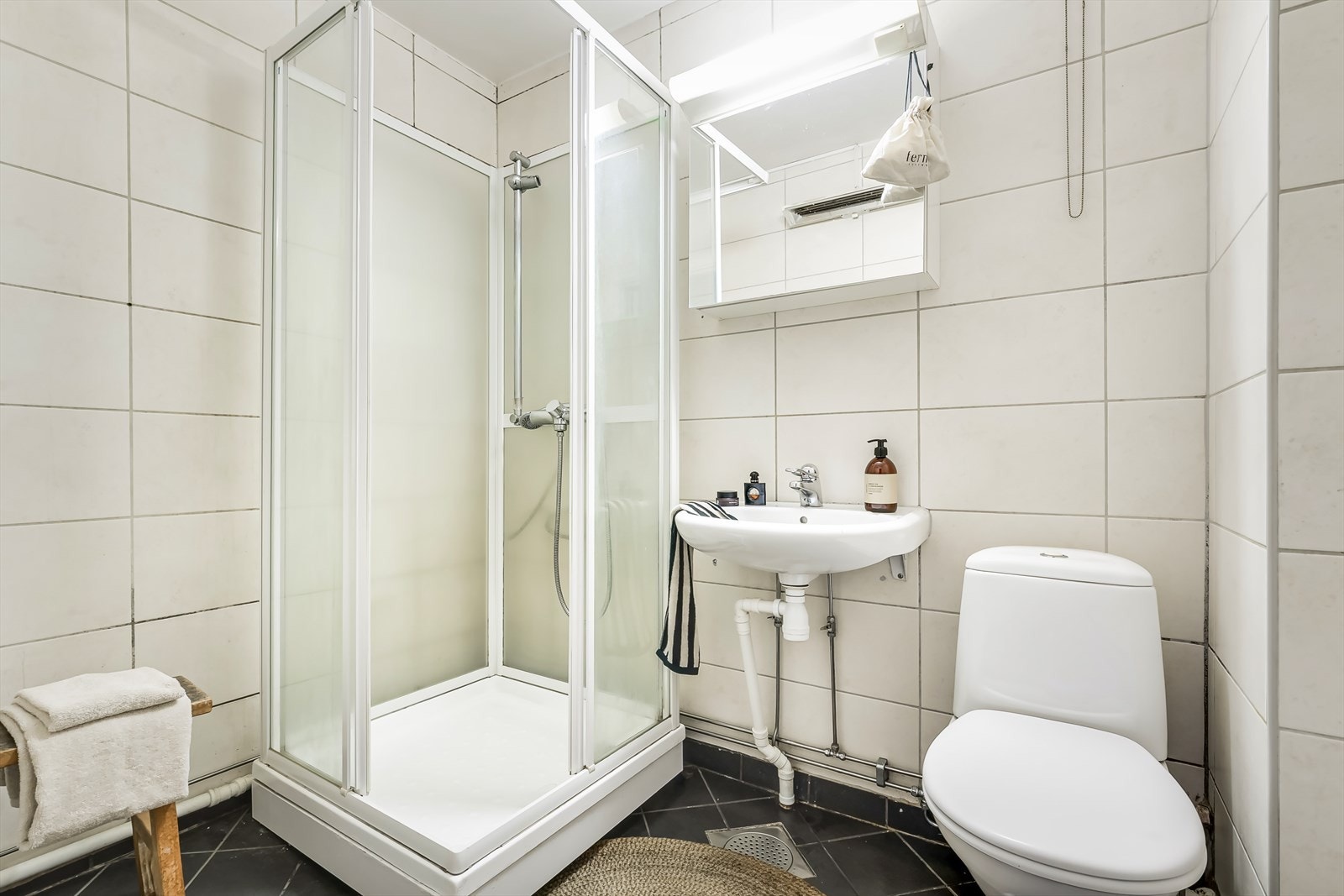 Eldre bad med flislagte overflater og dusjkabinett. Galleribilde