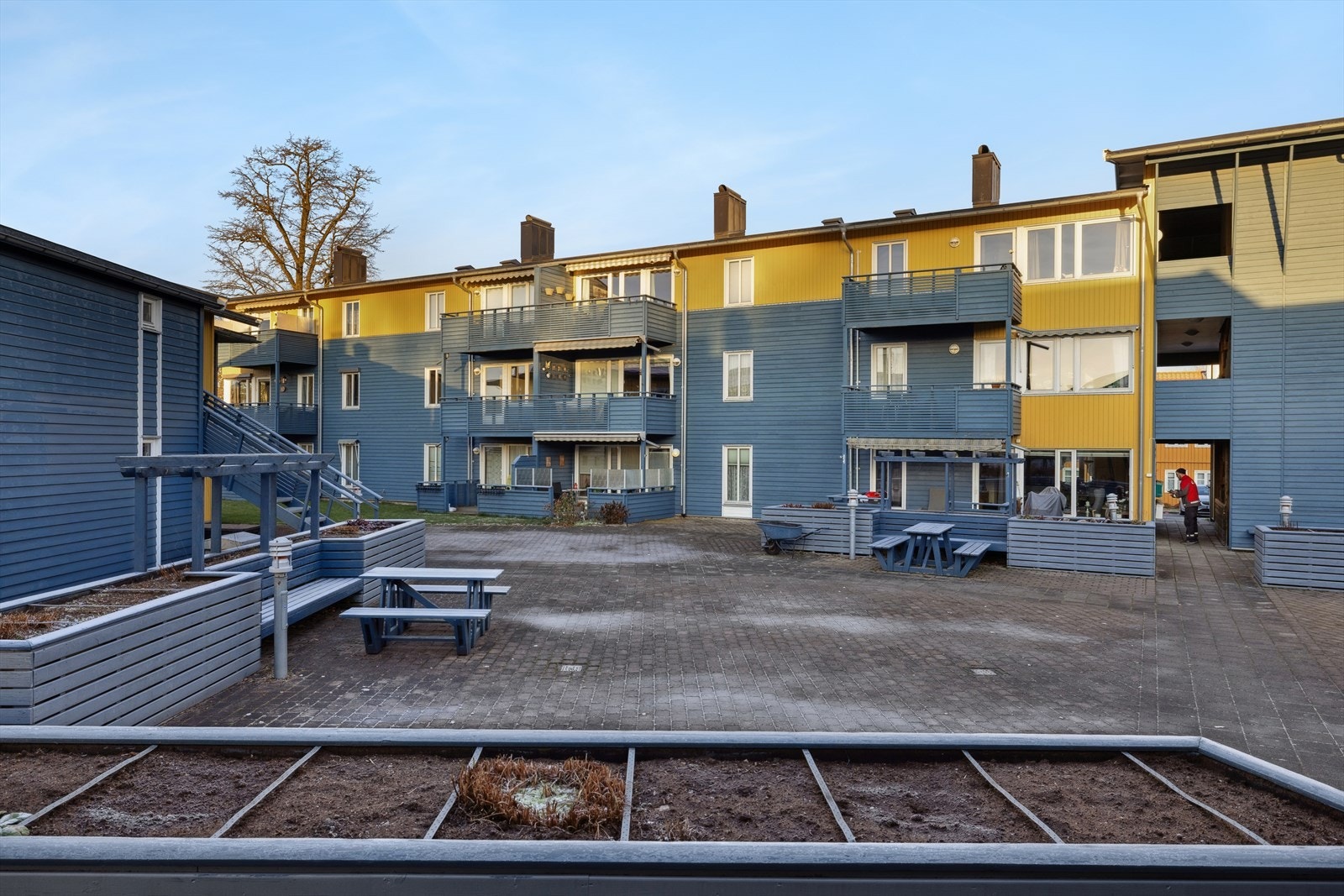 Pent fellesområdet med belegningsstein, plantekasser og sittegrupper. Galleribilde