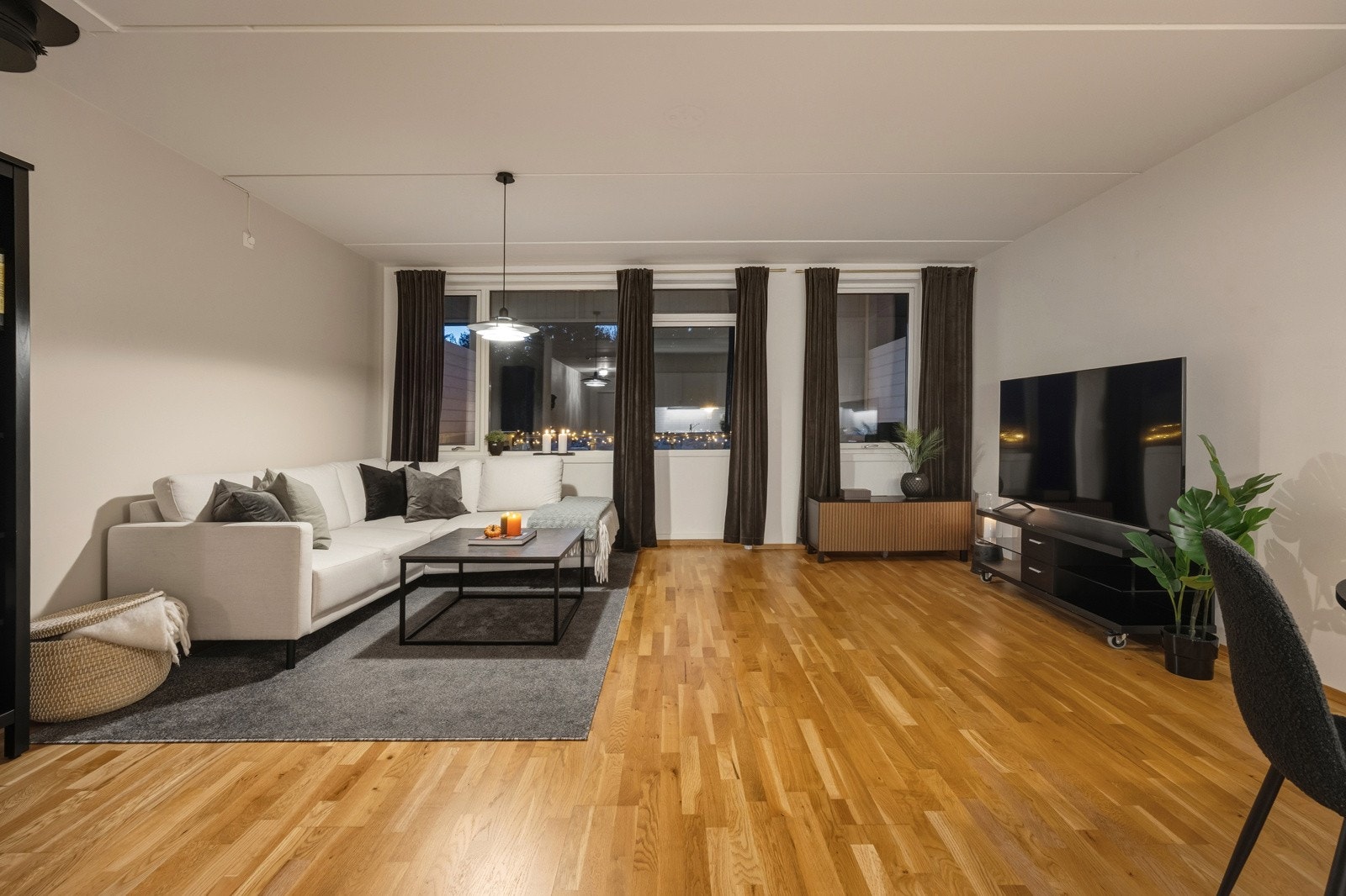 Stuen fremstår som svært innbydende i lyse, tidsriktige fargevalg. På gulvet er det lagt trestavs eikeparkett som strekker seg sømløst gjennom leiligheten. Galleribilde