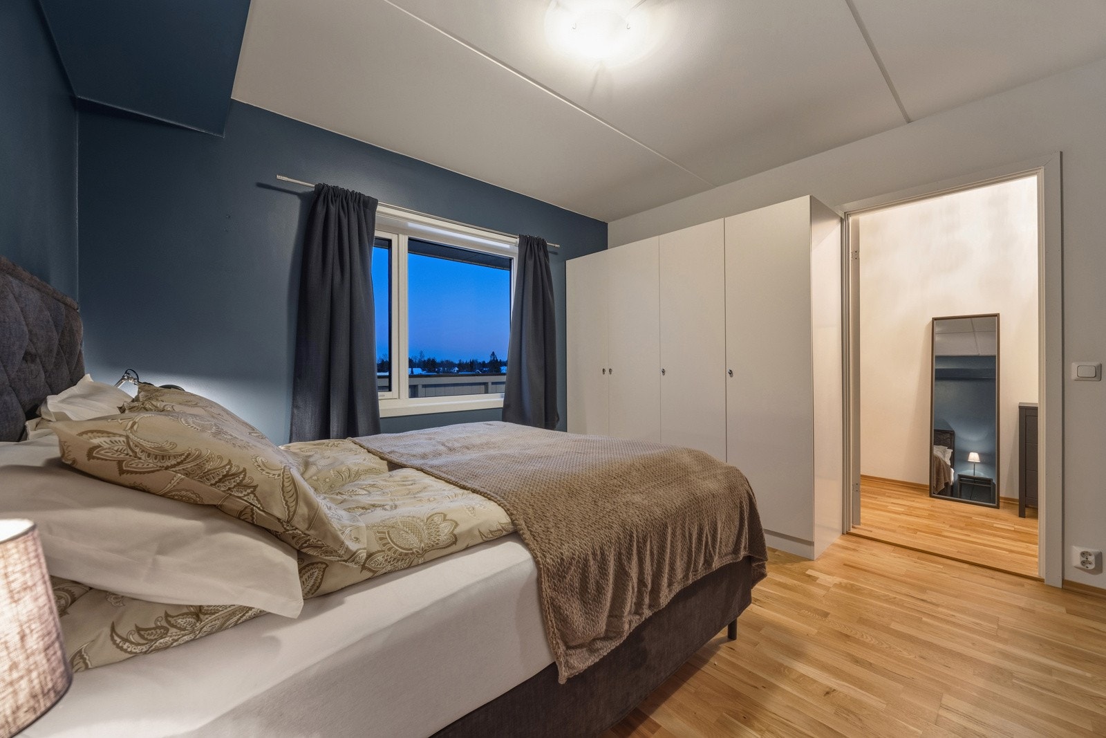 Leiligheten har et tiltalende soverom med samme gode kvalitet og standard som leiligheten for øvrig. Rommet har malte slette veggflater, trestavs eikeparkett på gulv og garderobeskap. Galleribilde