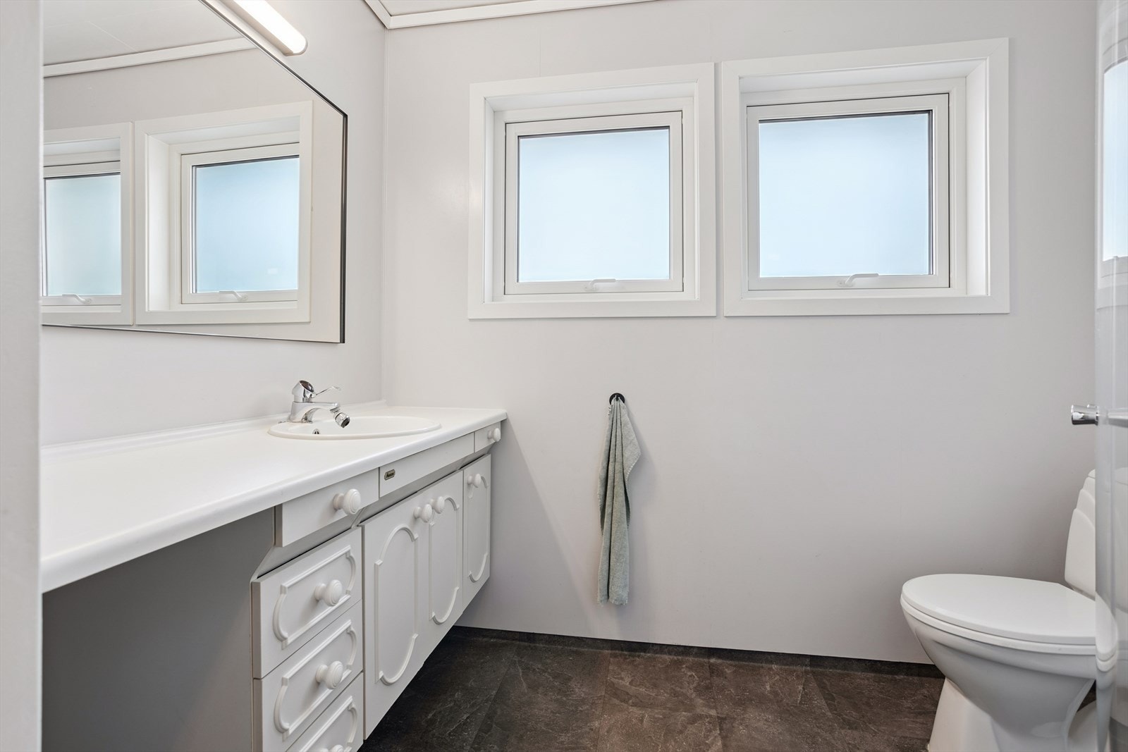 Bad på 3,9 m² med belegg på gulv og malte plater på vegg Galleribilde