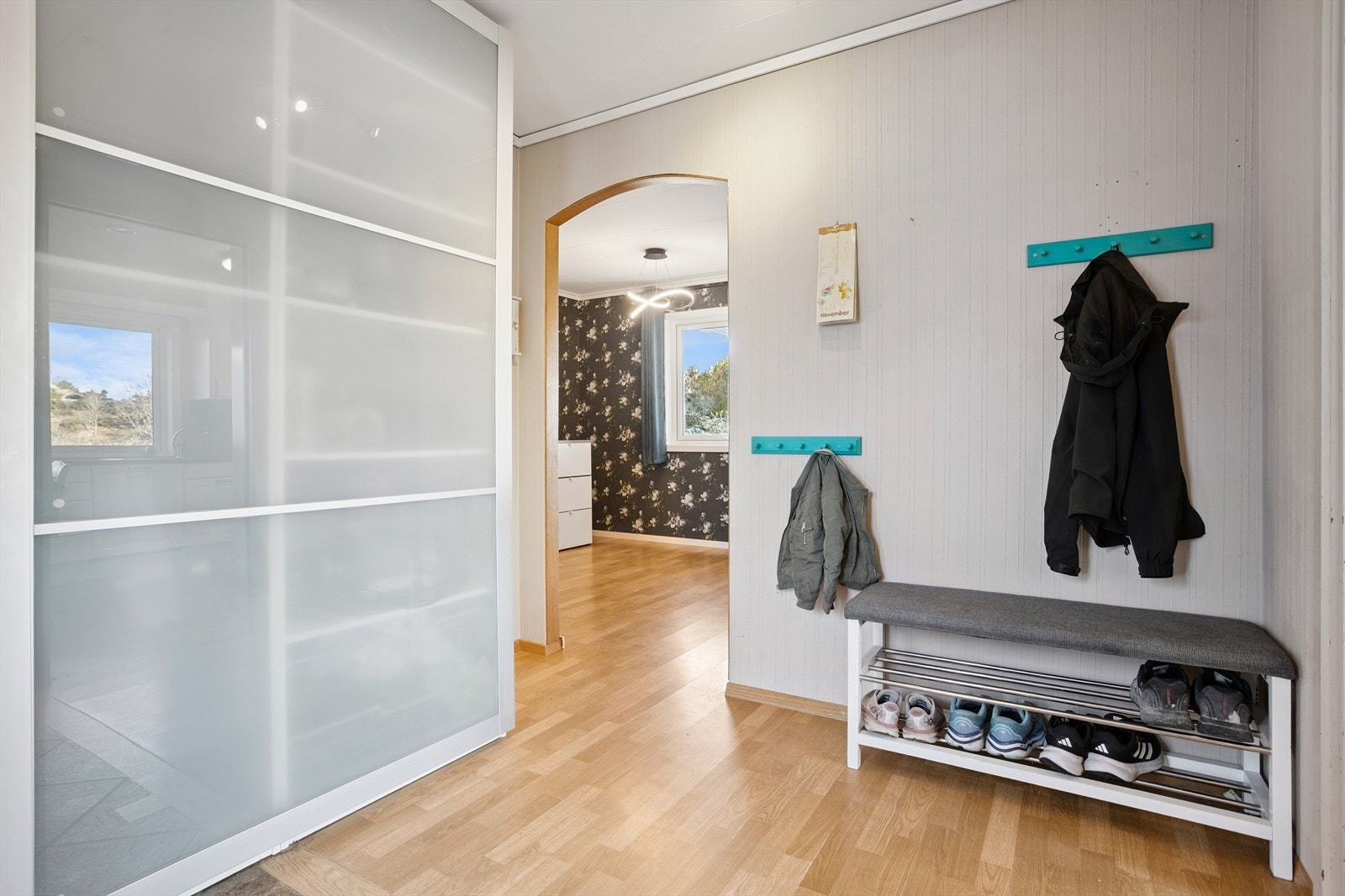 Romslig entré med stor skyvedørsgarderobe Galleribilde