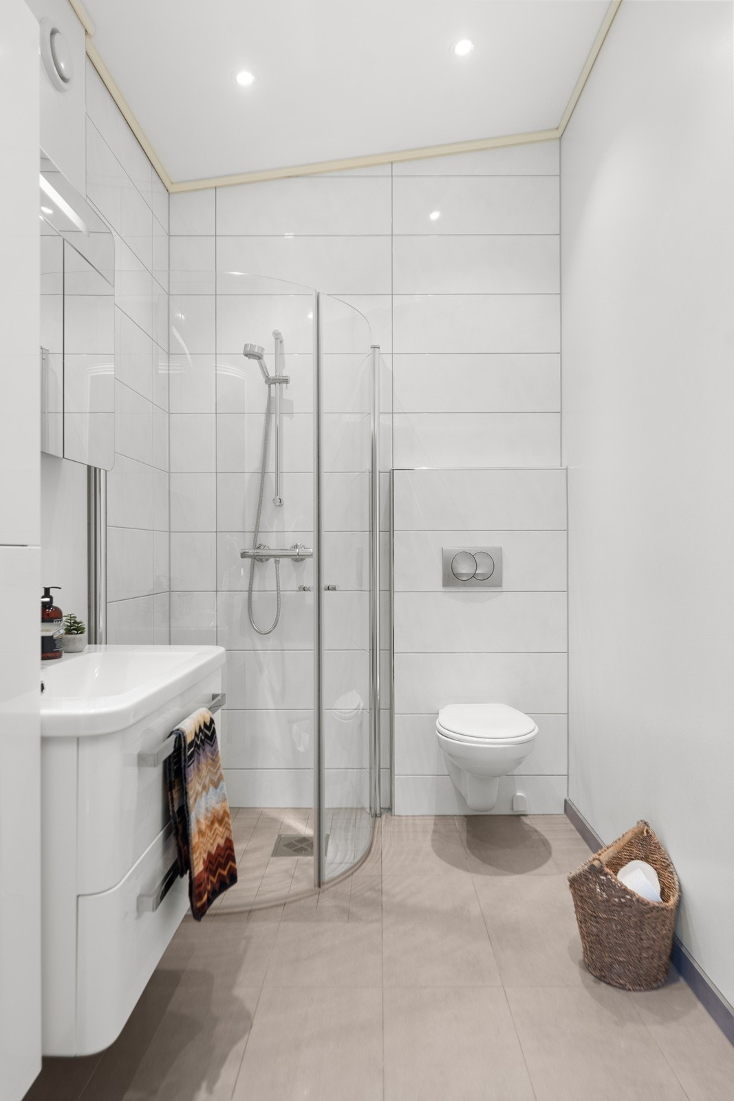 Bad tilhørende hovedsoverom. Servant, vegghengt wc og dusjhjørne. Flislagt gulv med varme Galleribilde